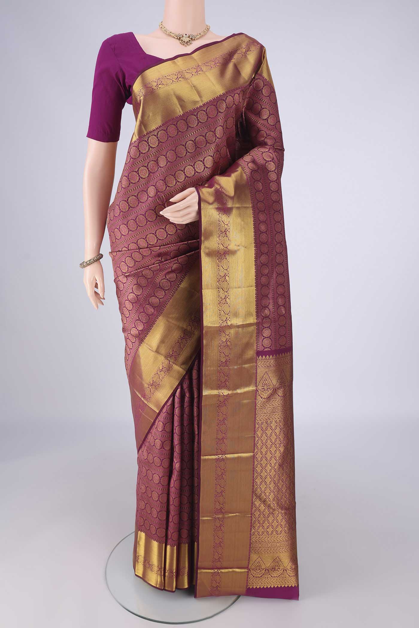 Burgundy Kanjivaram Silk Saree with Zari Brocade on the body and Zari Border.  displayed on a mannequin