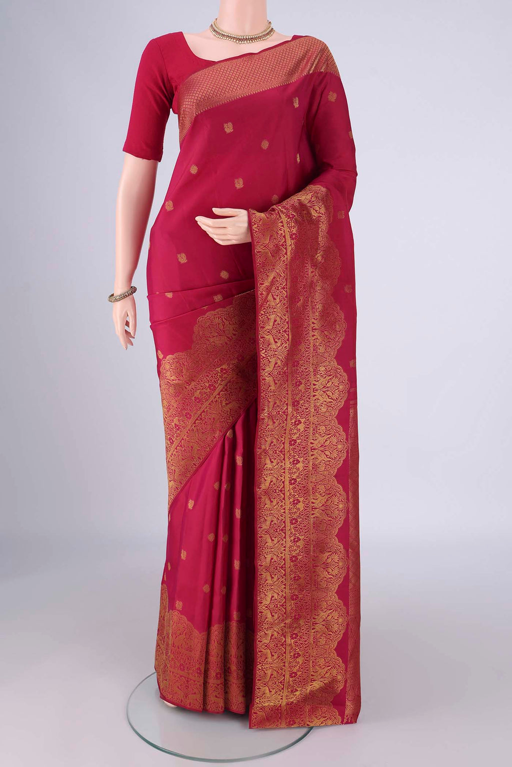 Maroon Kanchipuram Silk Saree with Zari Butta on the body and Zari Border.  displayed on a mannequin