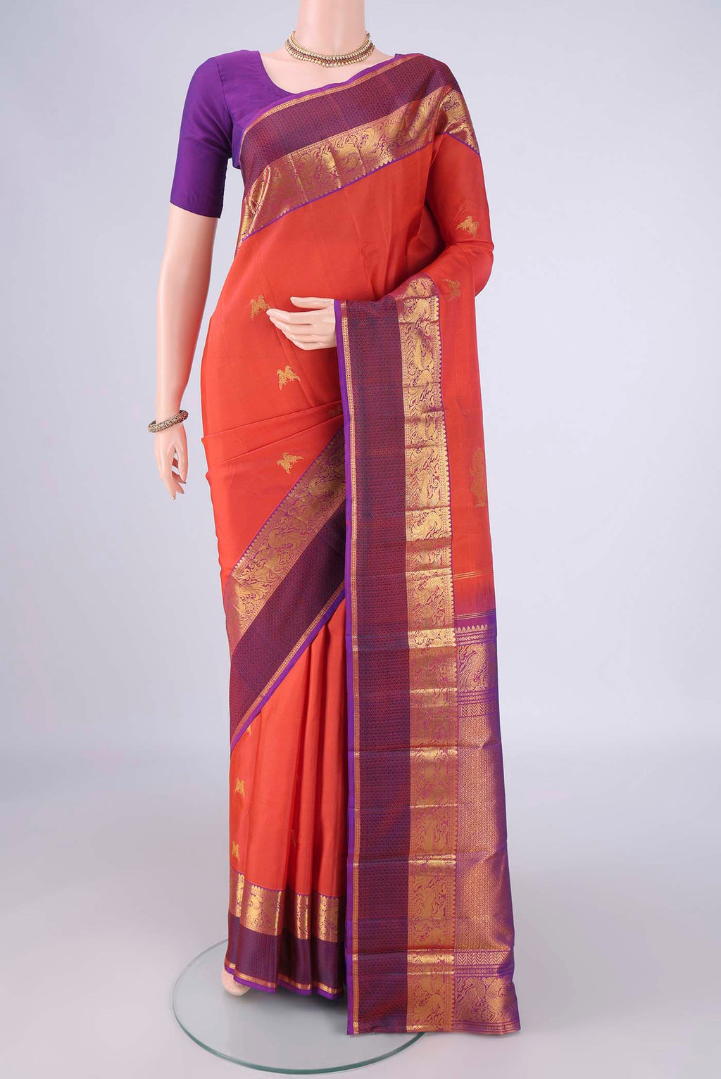Rust Dual Tone Kanjivaram Silk Saree with Zari Butta on the body and Zari Border.  displayed on a mannequin