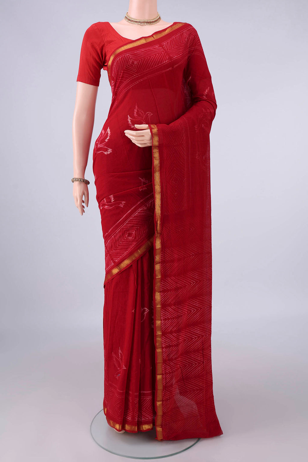 Red Cotton Saree with Printed design on the body and Zari Border.  displayed on a mannequin