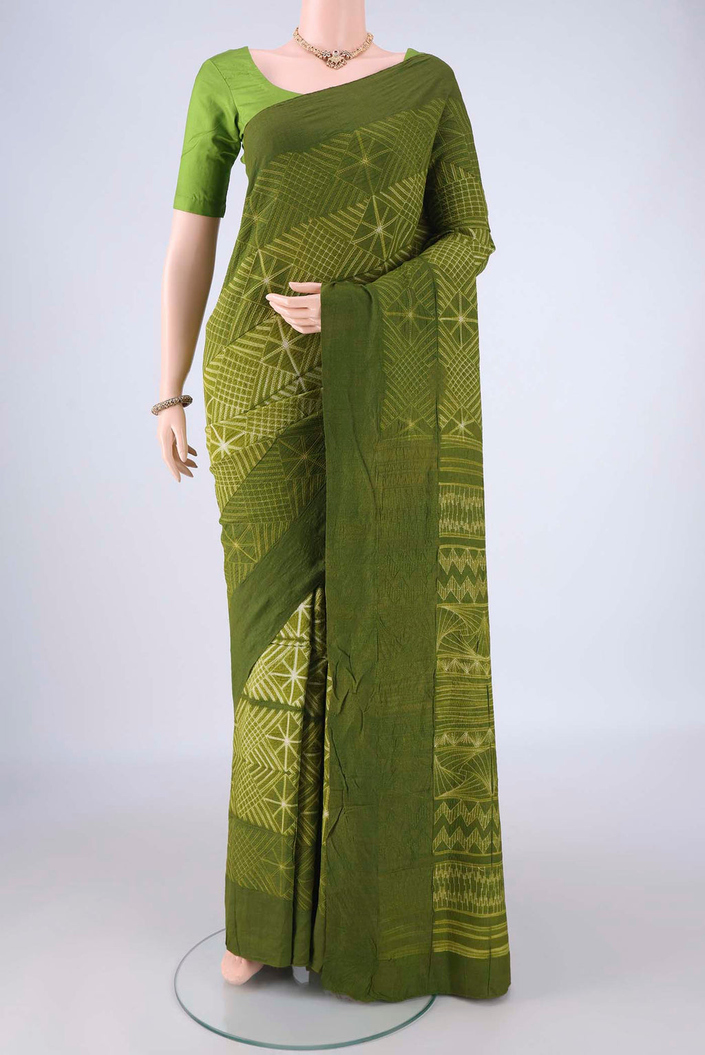 Mehandi Green Tussar Silk Saree with Printed design on the body and Plain Border.  displayed on a mannequin