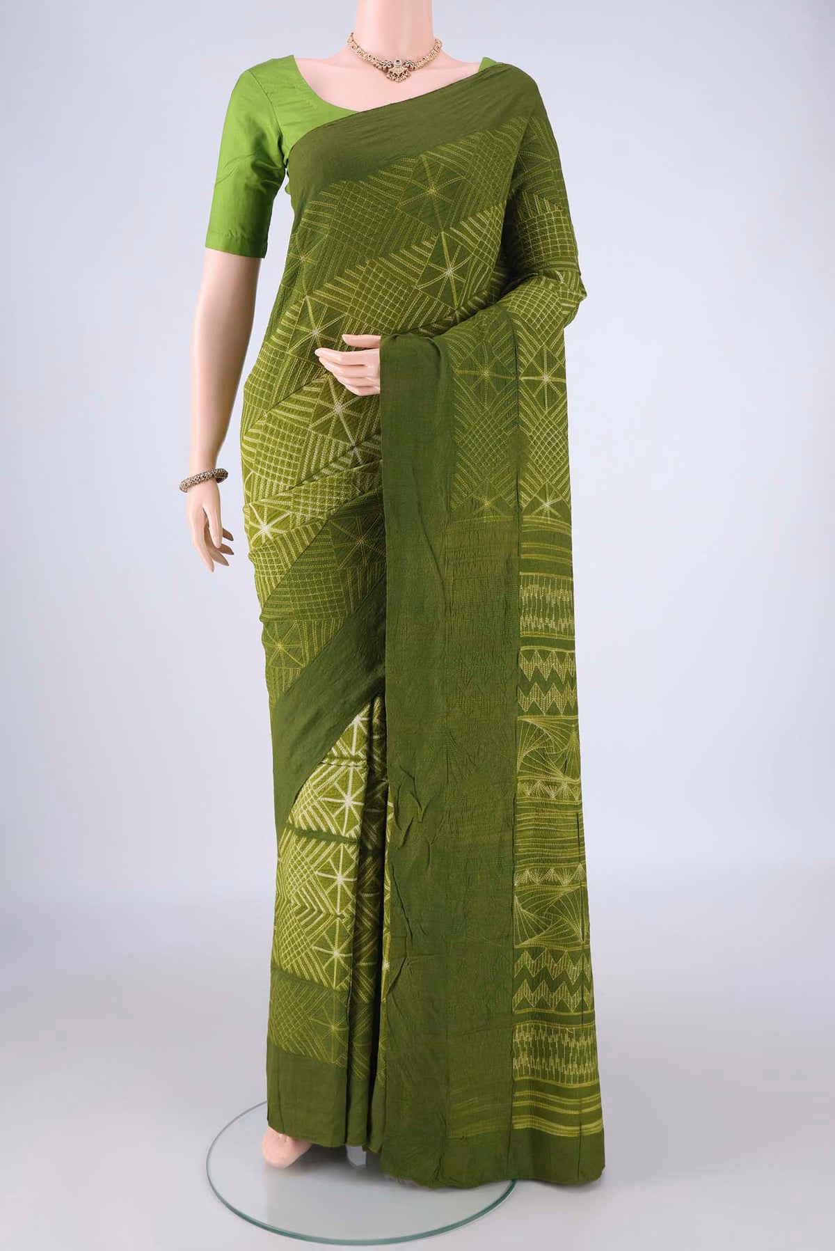 Mehandi Green Tussar Silk Saree with Printed design on the body and Plain Border.  displayed on a mannequin