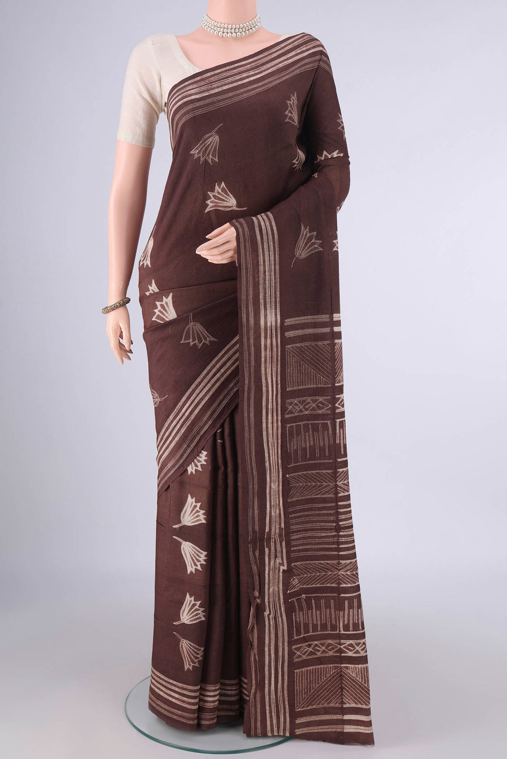 Brown Tussar Saree with Printed design on the body and Printed Border.  displayed on a mannequin