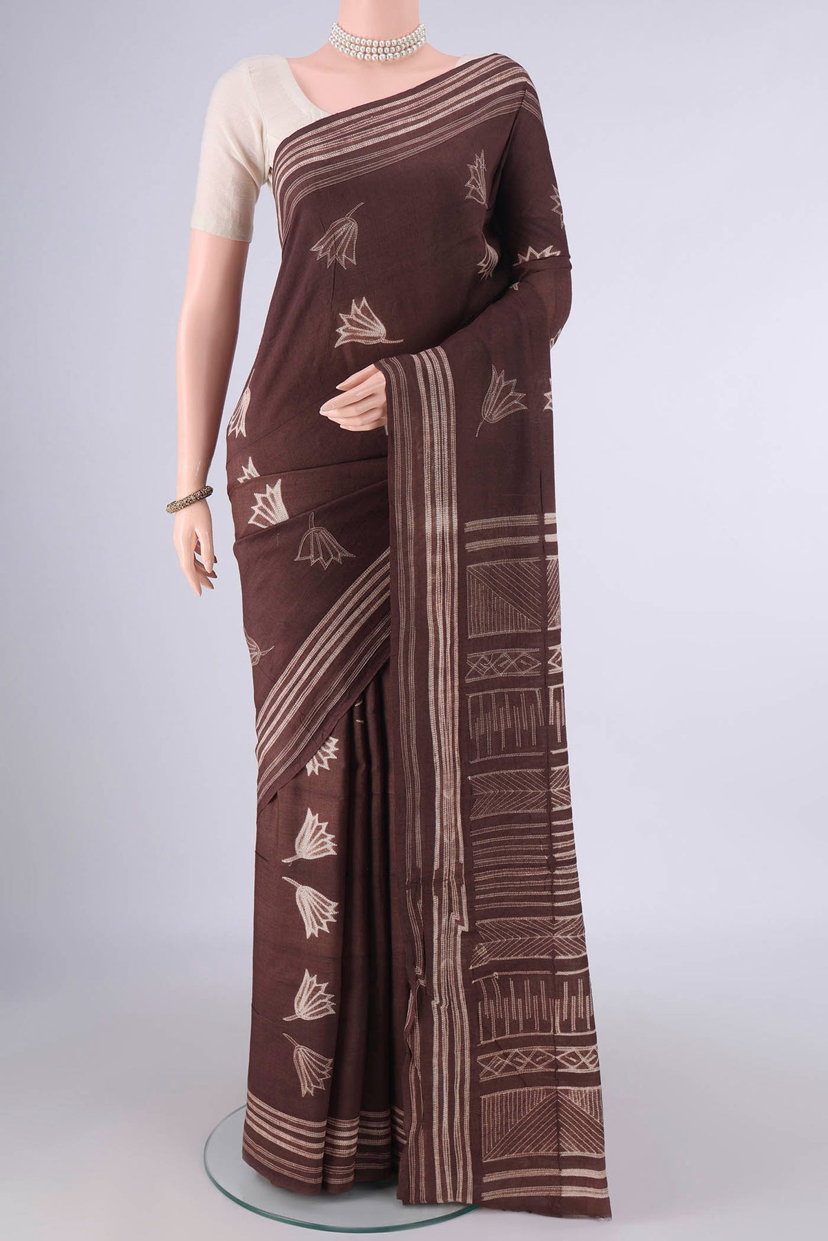 Brown Tussar Saree with Printed design on the body and Printed Border.  displayed on a mannequin