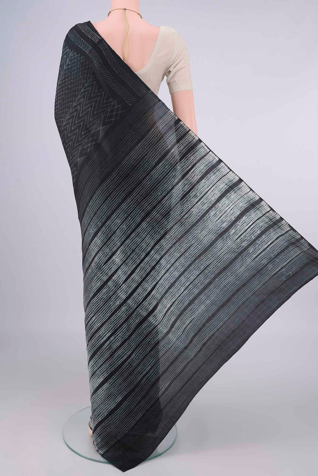 Flat view of Pure Silk Black Printed Saree with Printed design on the body and Printed Border. 