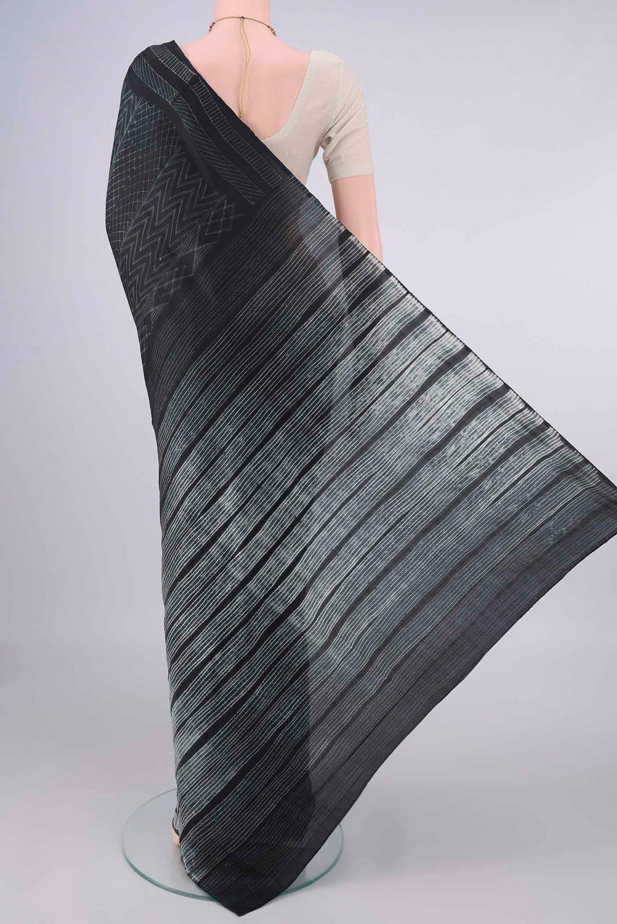 Flat view of Pure Silk Black Printed Saree with Printed design on the body and Printed Border. 