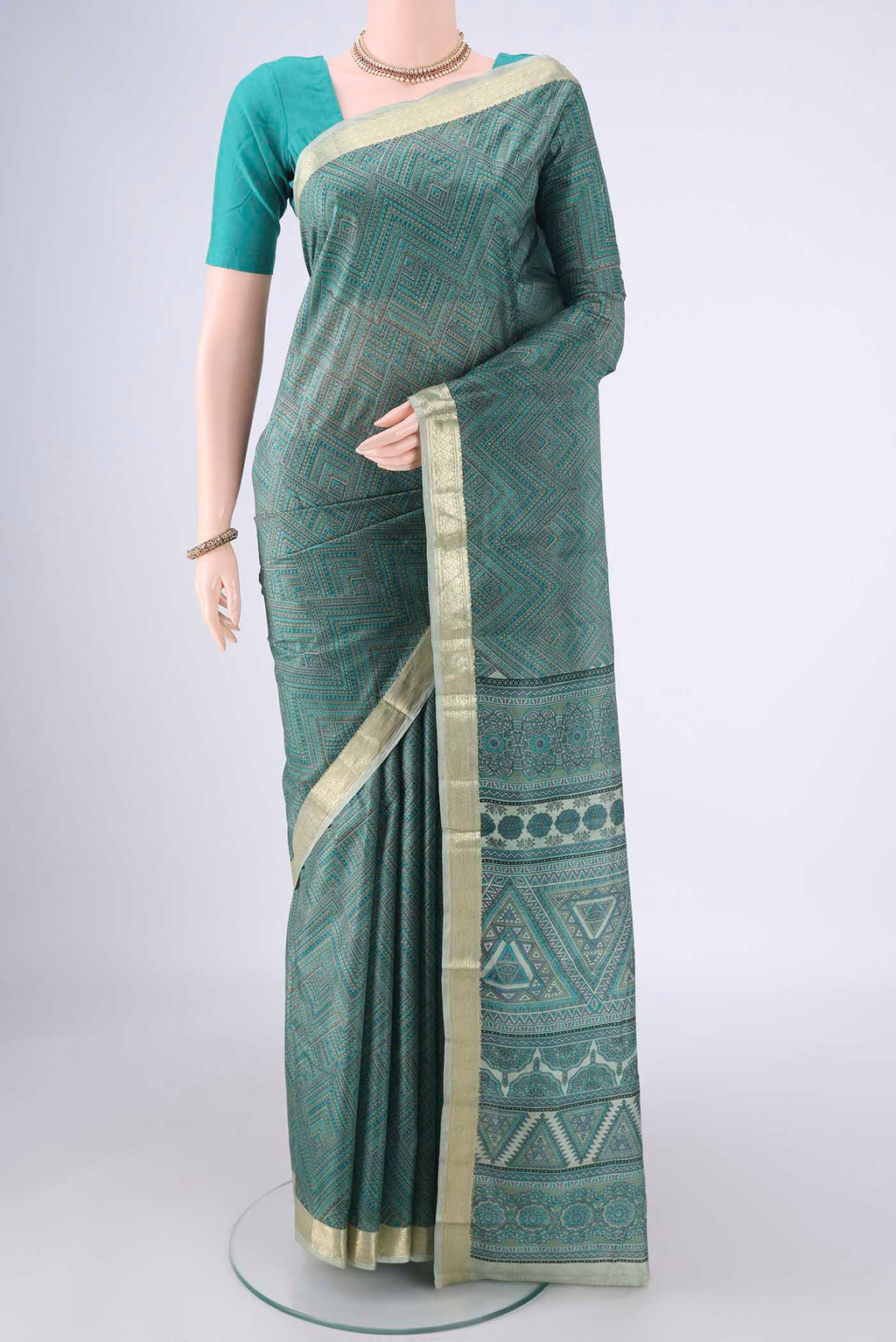Sage Green Printed Silk Saree with Printed design on the body and Zari Border.  displayed on a mannequin