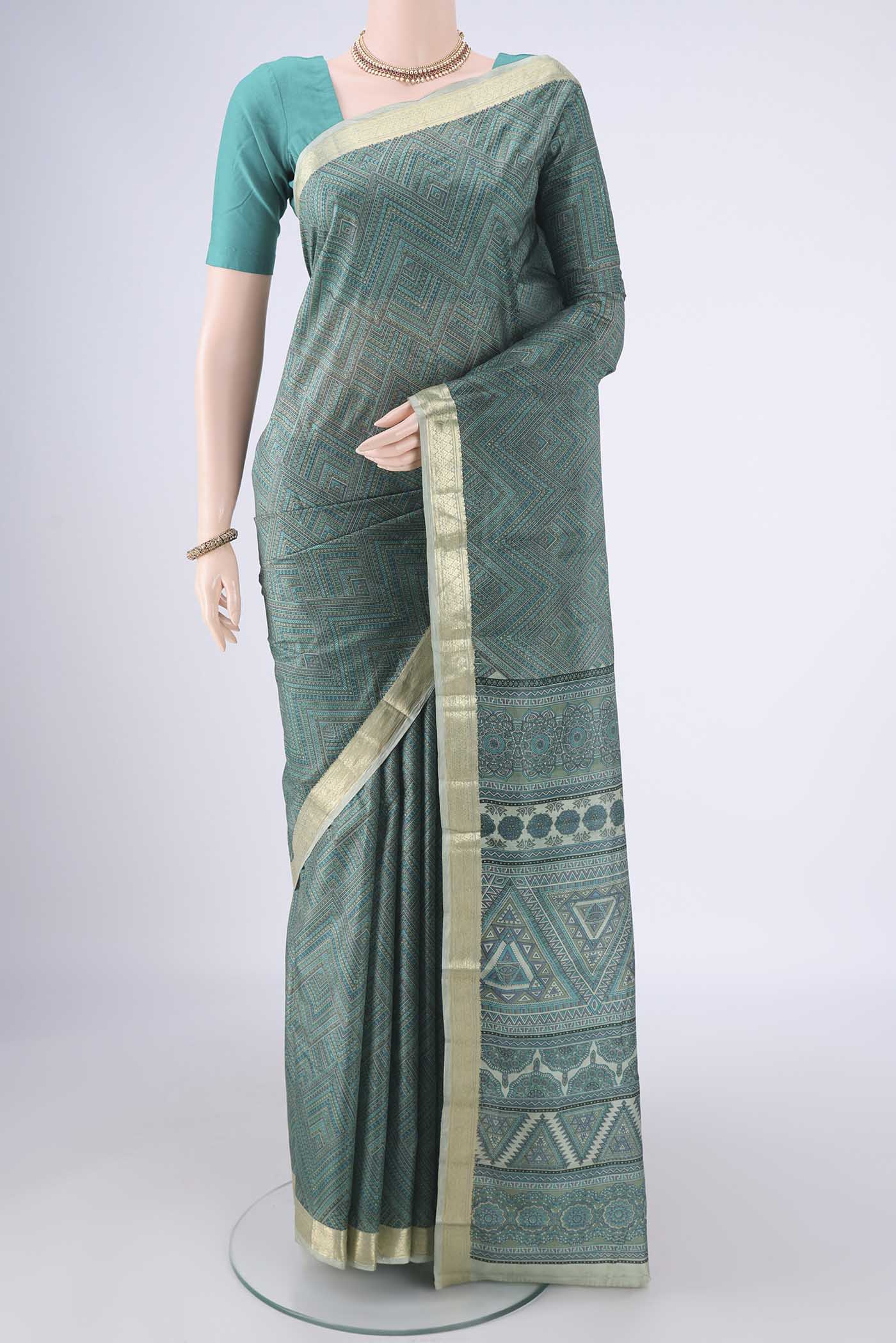 Sage Green Printed Silk Saree with Printed design on the body and Zari Border.  displayed on a mannequin