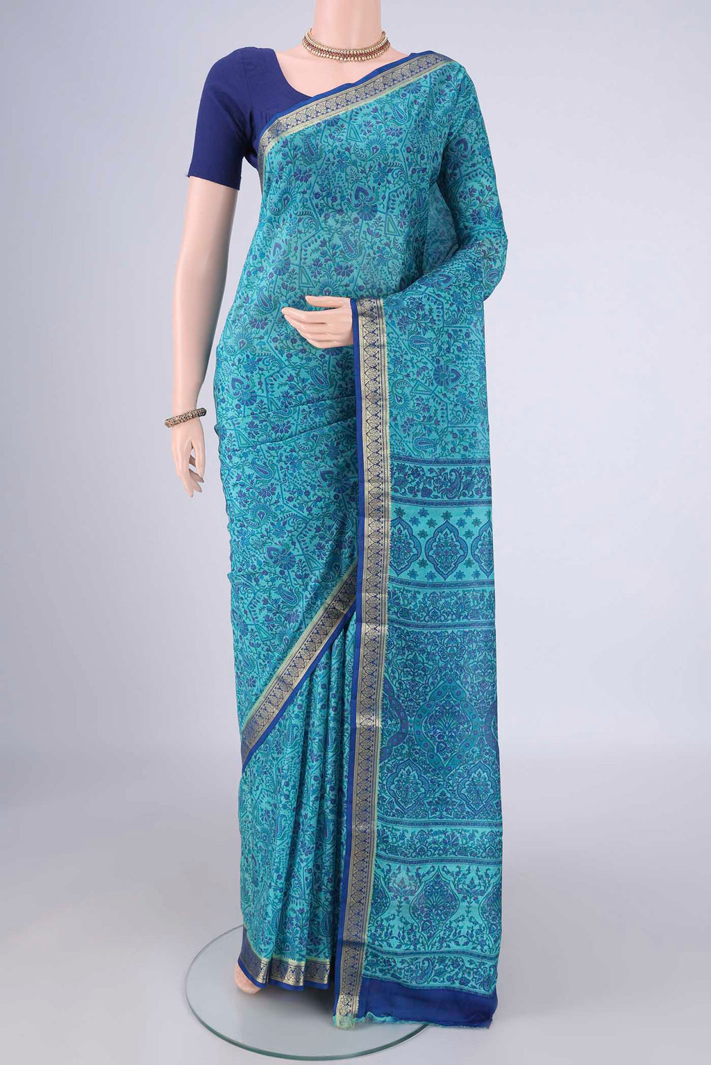 Blue Printed Silk Saree with Printed design on the body and Zari Border.  displayed on a mannequin