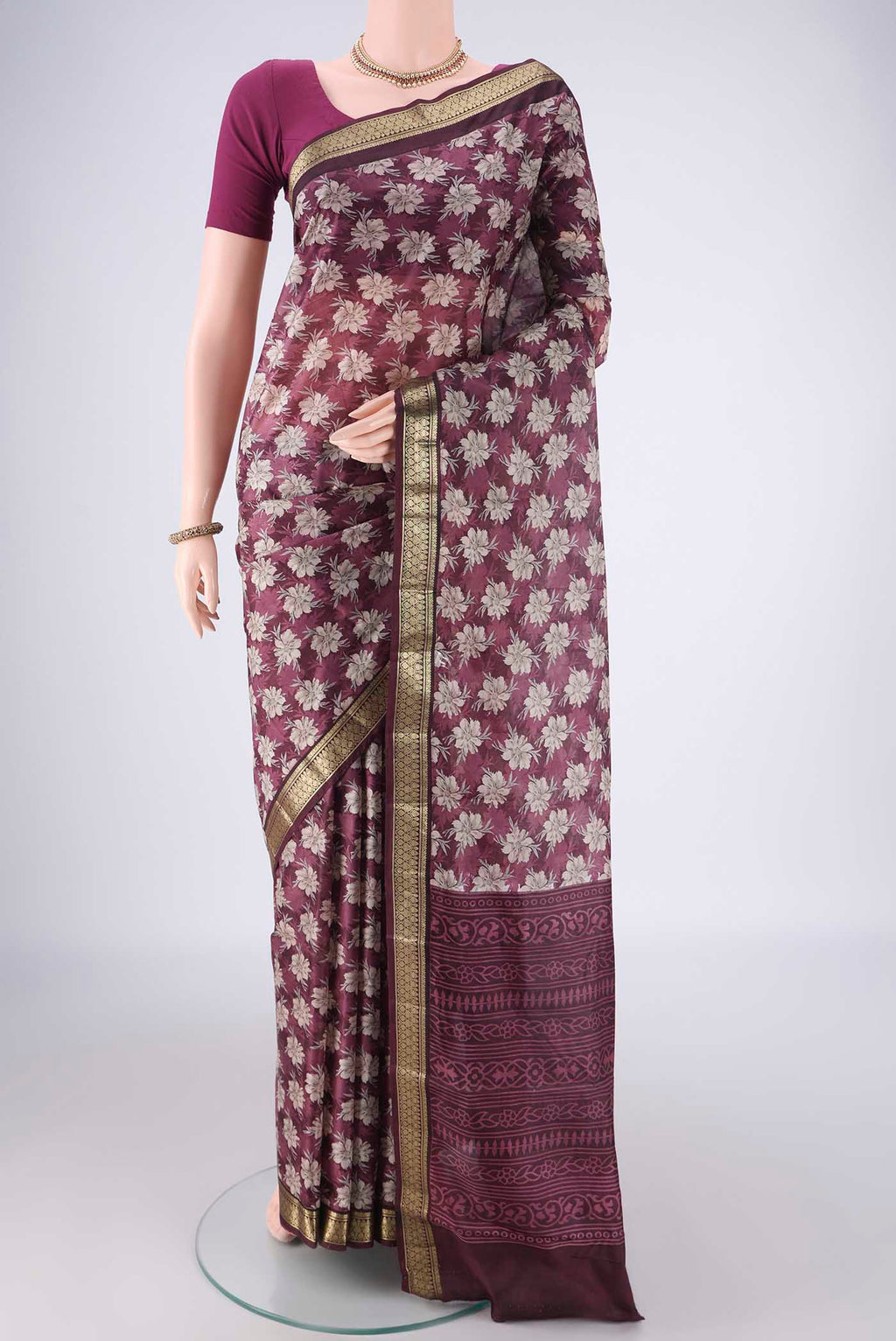 Burgundy Printed Silk Saree with Printed design on the body and Zari Border.  displayed on a mannequin