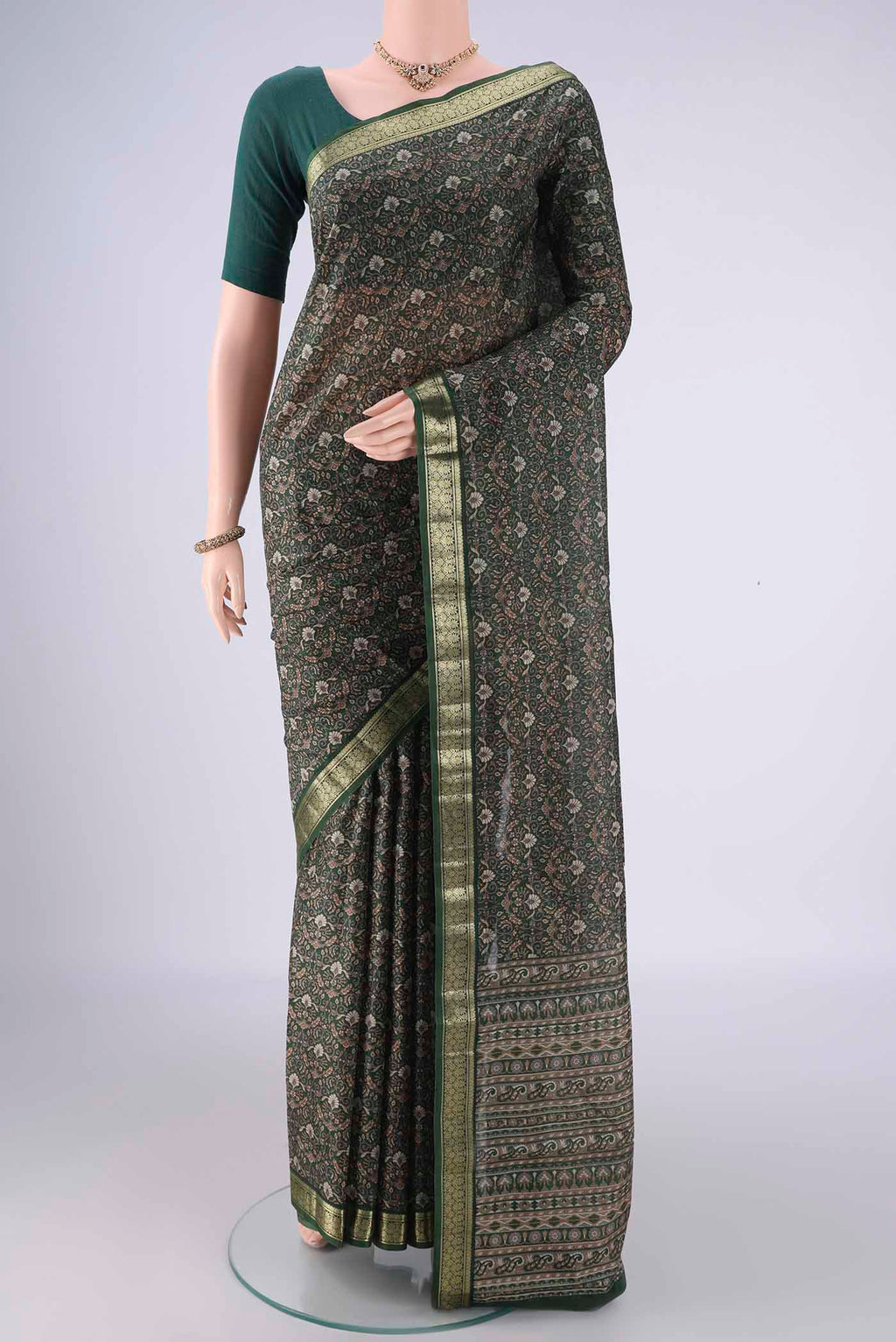 Bottle Green Printed Silk Saree with Printed design on the body and Zari Border.  displayed on a mannequin