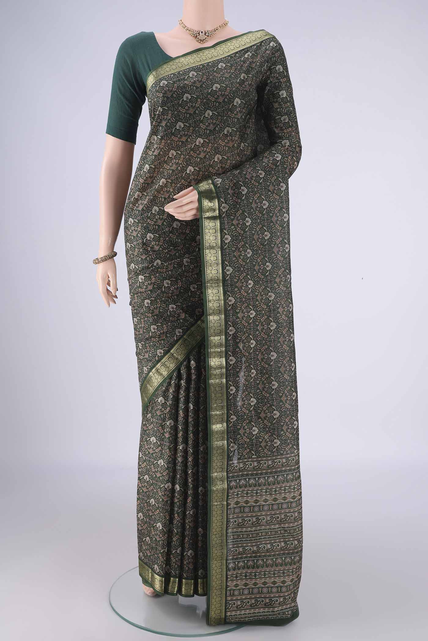 Bottle Green Printed Silk Saree with Printed design on the body and Zari Border.  displayed on a mannequin