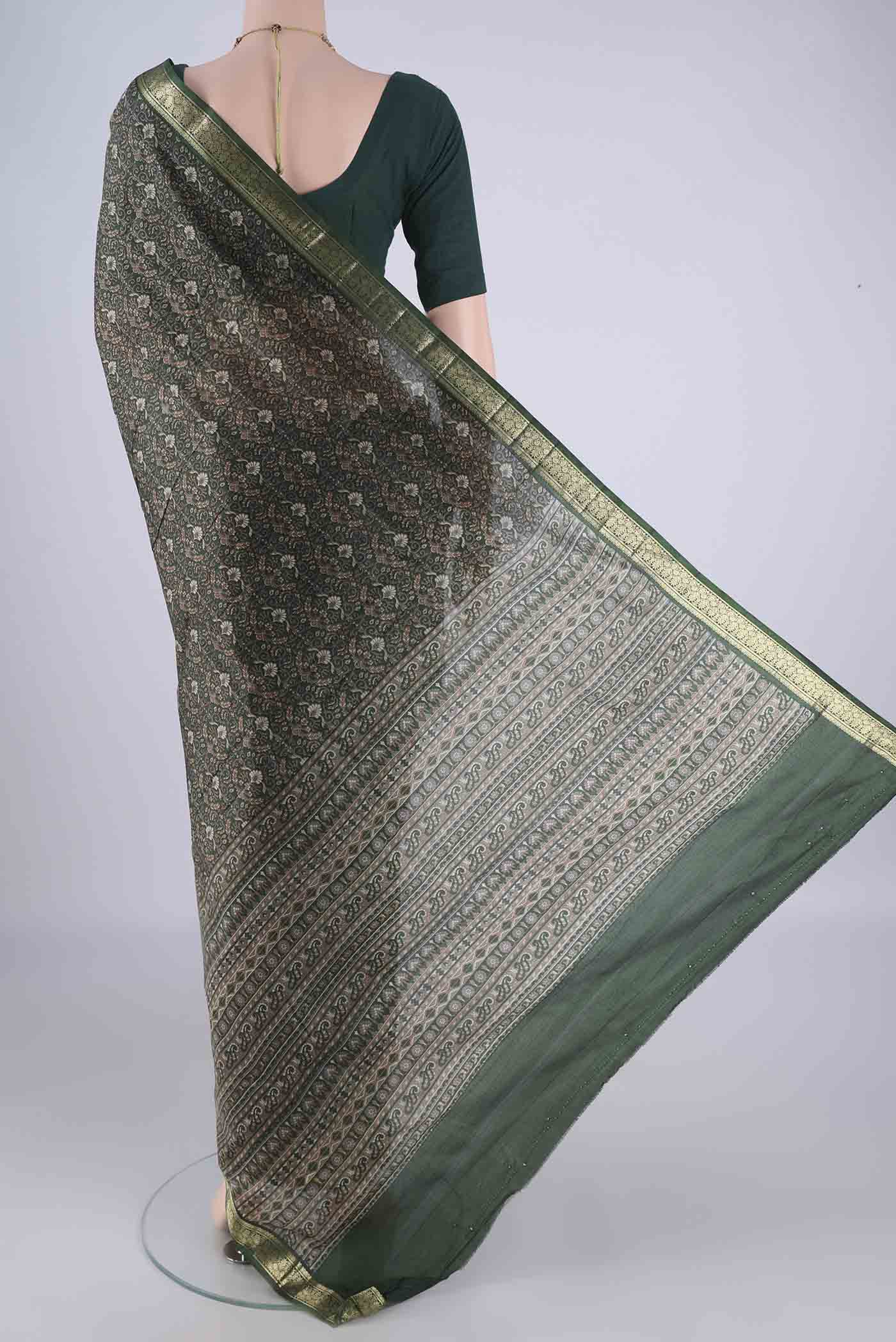 Flat view of Bottle Green Printed Silk Saree with Printed design on the body and Zari Border. 