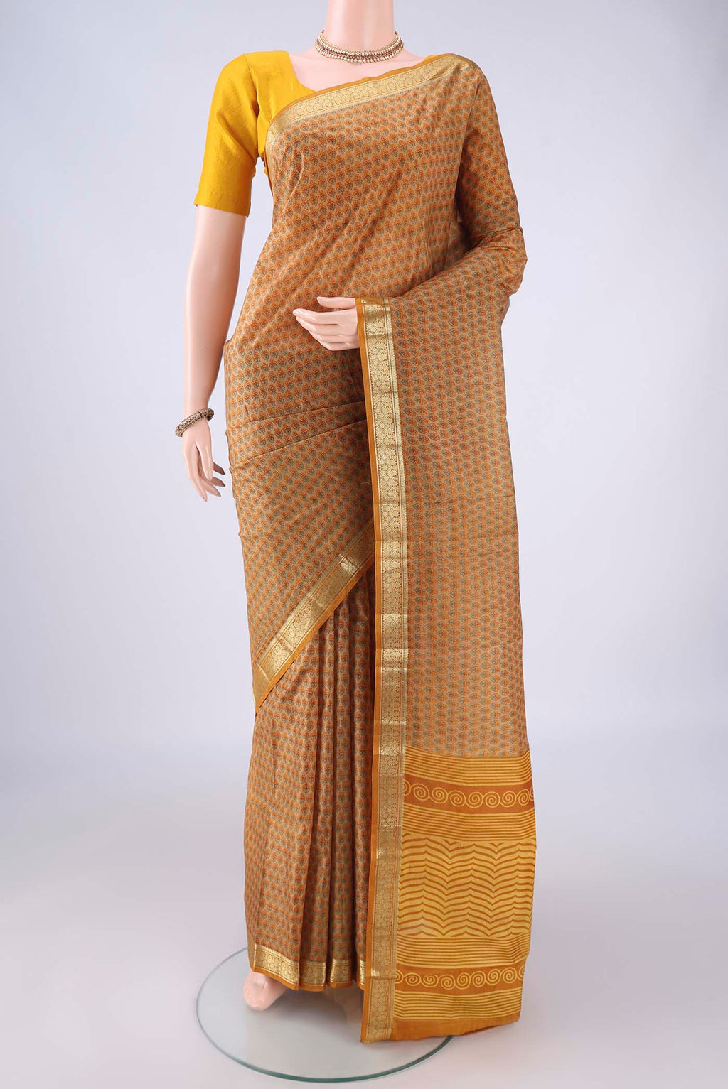 Dark Beige Printed Silk Saree with Printed design on the body and Zari Border.  displayed on a mannequin