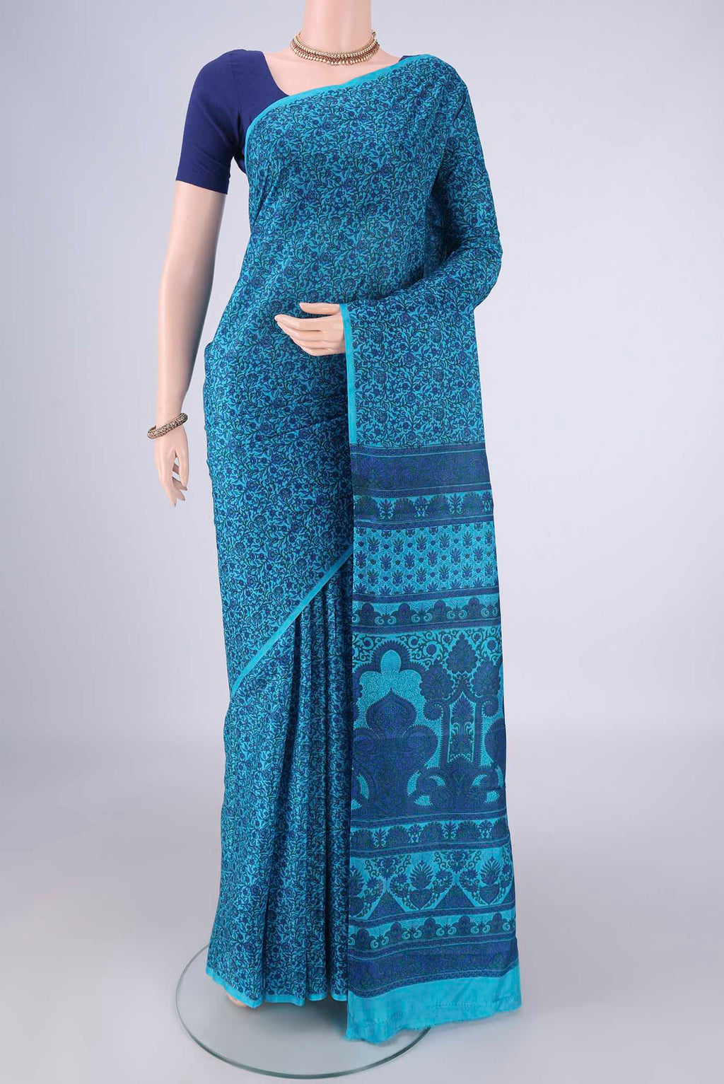 Blue Printed Silk Saree with Printed design on the body and Plain Border.  displayed on a mannequin