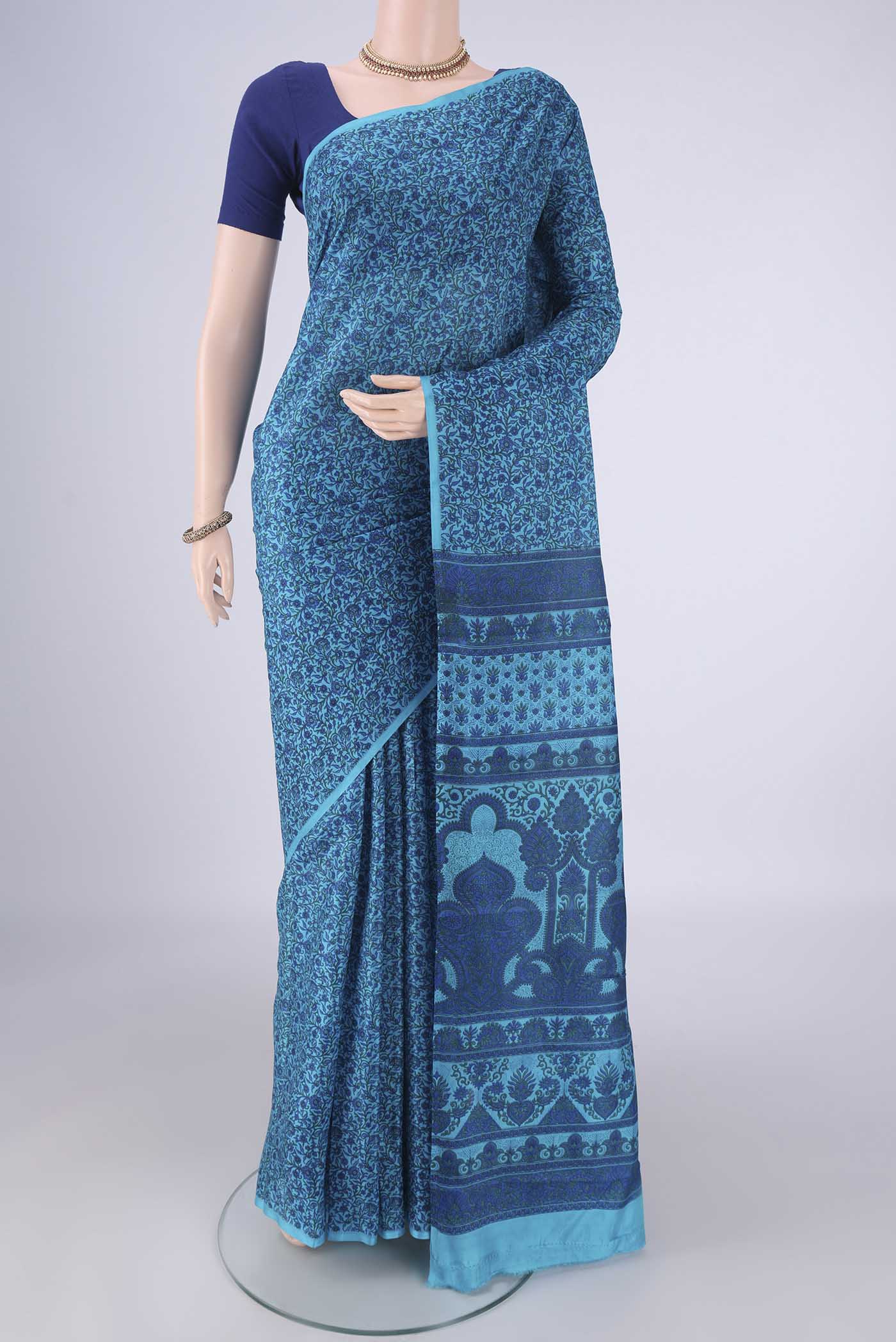 Blue Printed Silk Saree with Printed design on the body and Plain Border.  displayed on a mannequin