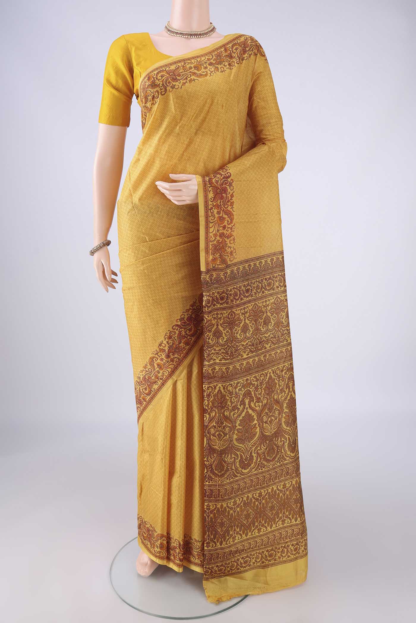 Mustard Printed Silk Saree with Printed design on the body and Printed Border.  displayed on a mannequin