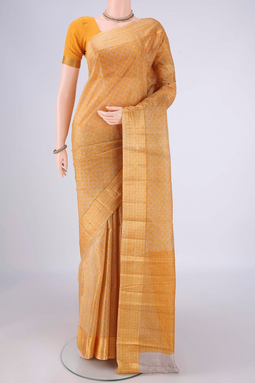 Beige Printed Silk Saree with Printed design on the body and Zari Border.  displayed on a mannequin