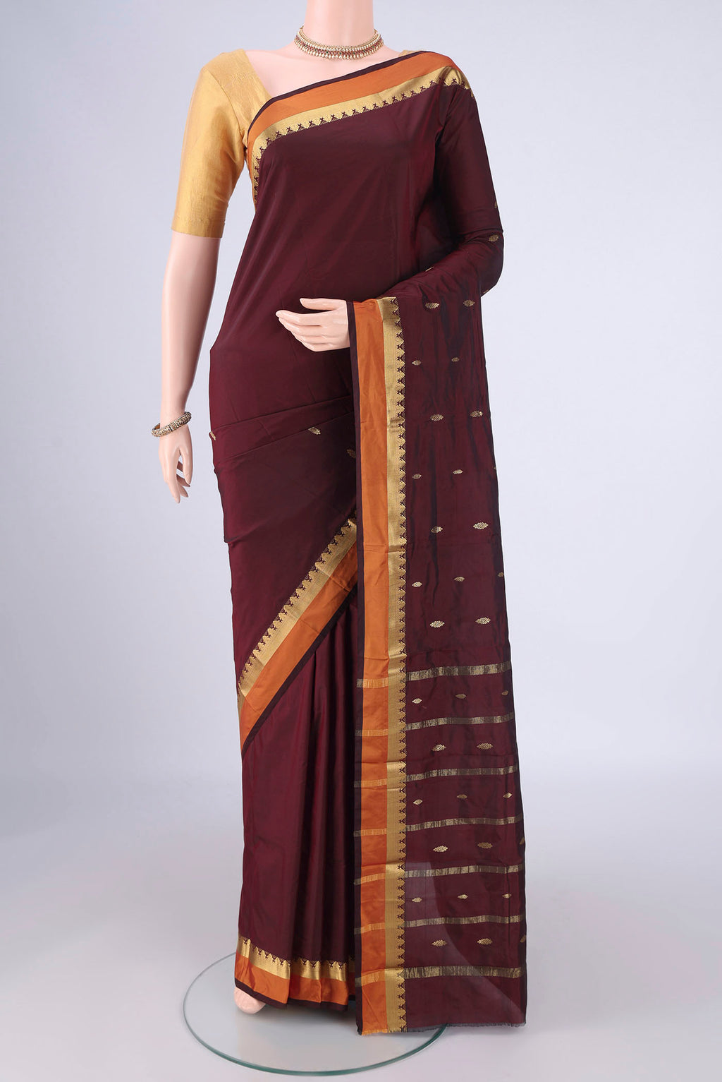 Maroon Blended Bangalore Silk Saree with Zari Butta on the body and Plain Border.  displayed on a mannequin