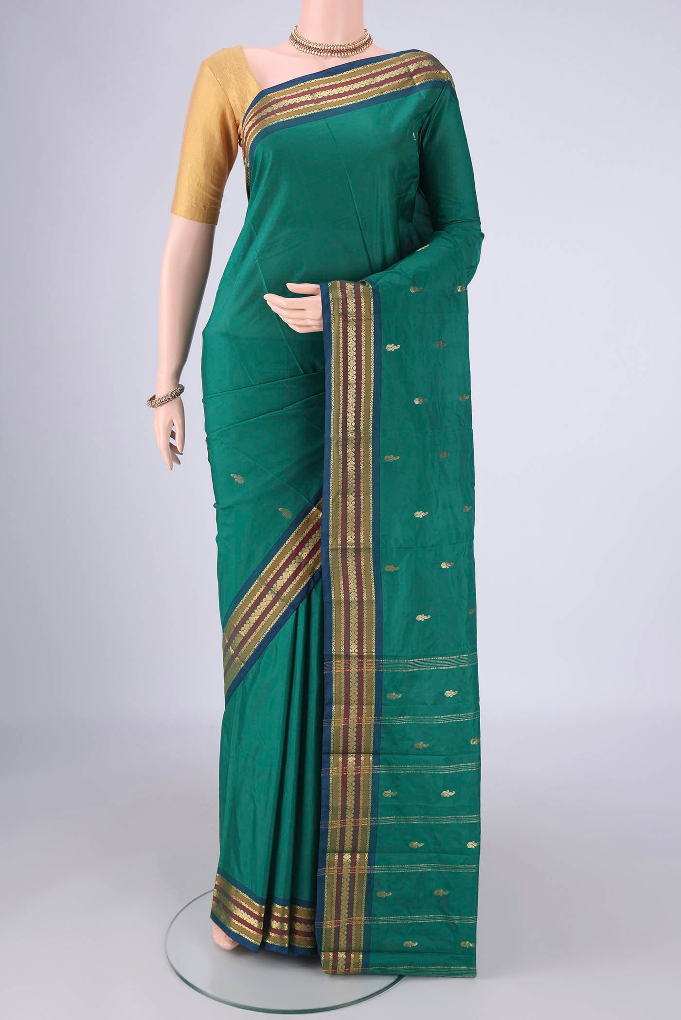 Green Blended Bangalore Silk Saree with Zari Butta on the body and Plain Border.  displayed on a mannequin