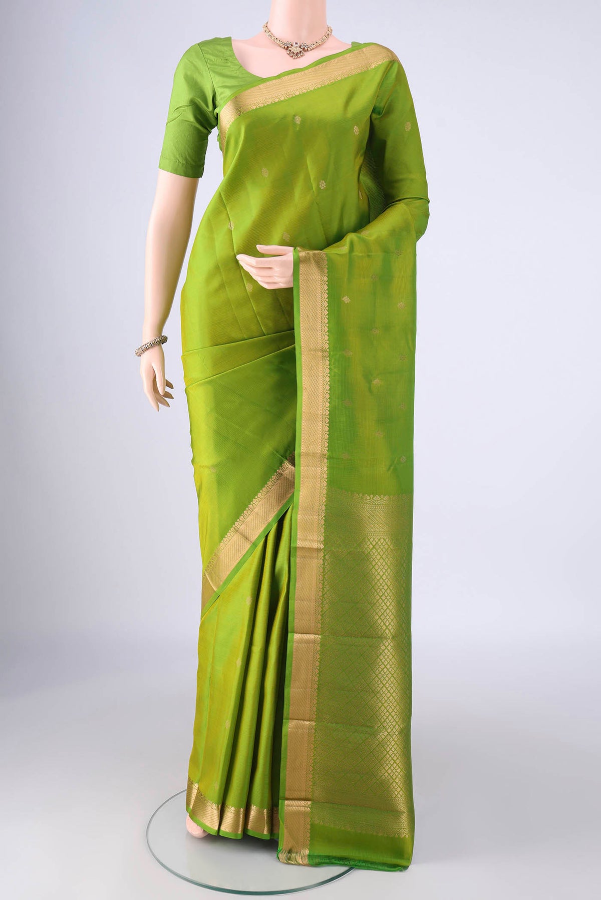 Light Green Kanjivaram Silk Saree with Zari Butta on the body and Zari Border.  displayed on a mannequin