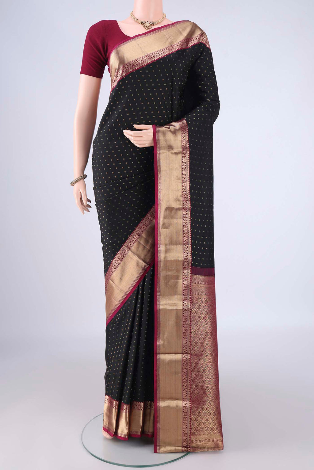 Black Kanchipuram Silk Saree with Zari Butta on the body and Zari Border.  displayed on a mannequin