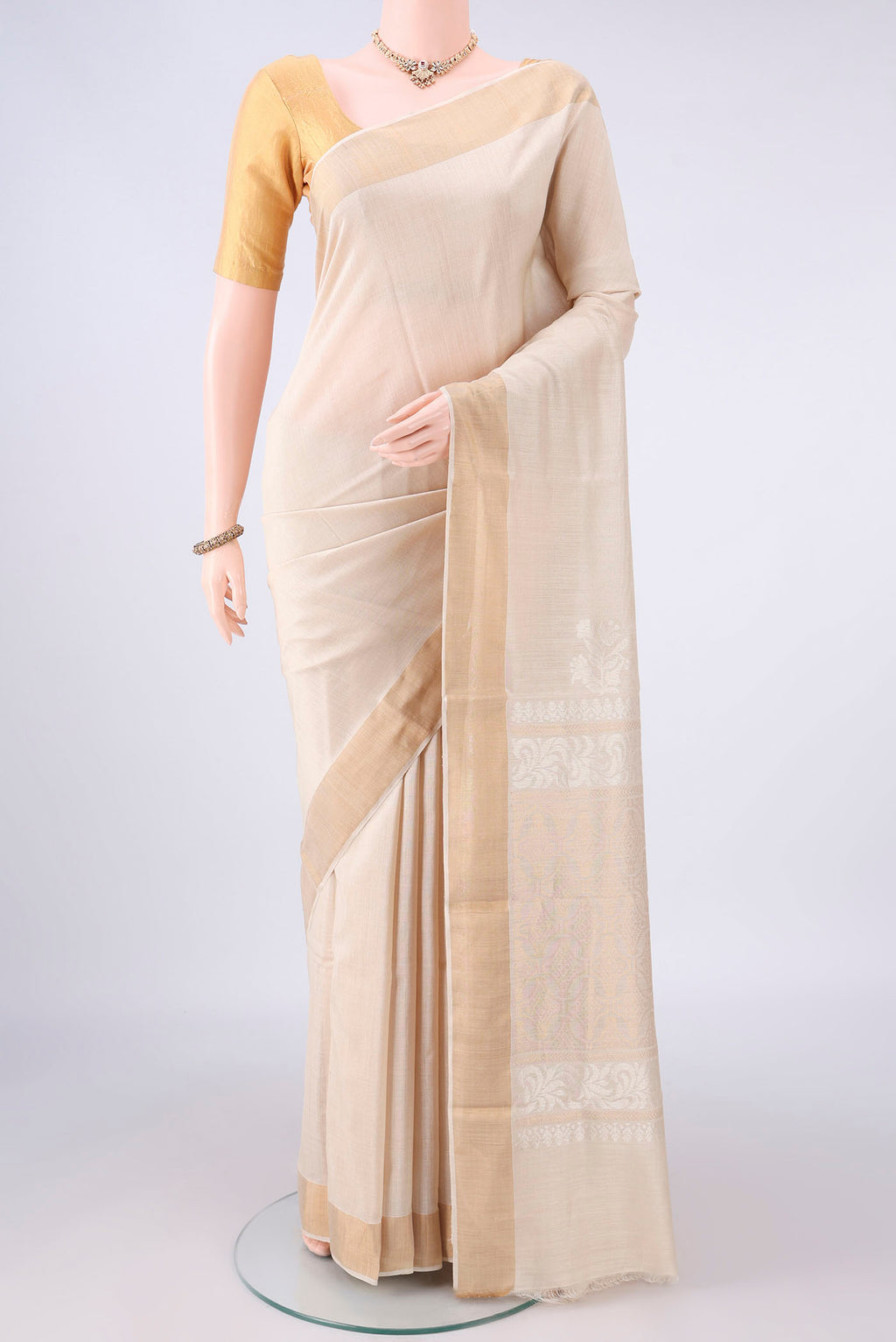 Beige MP Tussar Saree with Plain Body and Zari Border.  displayed on a mannequin