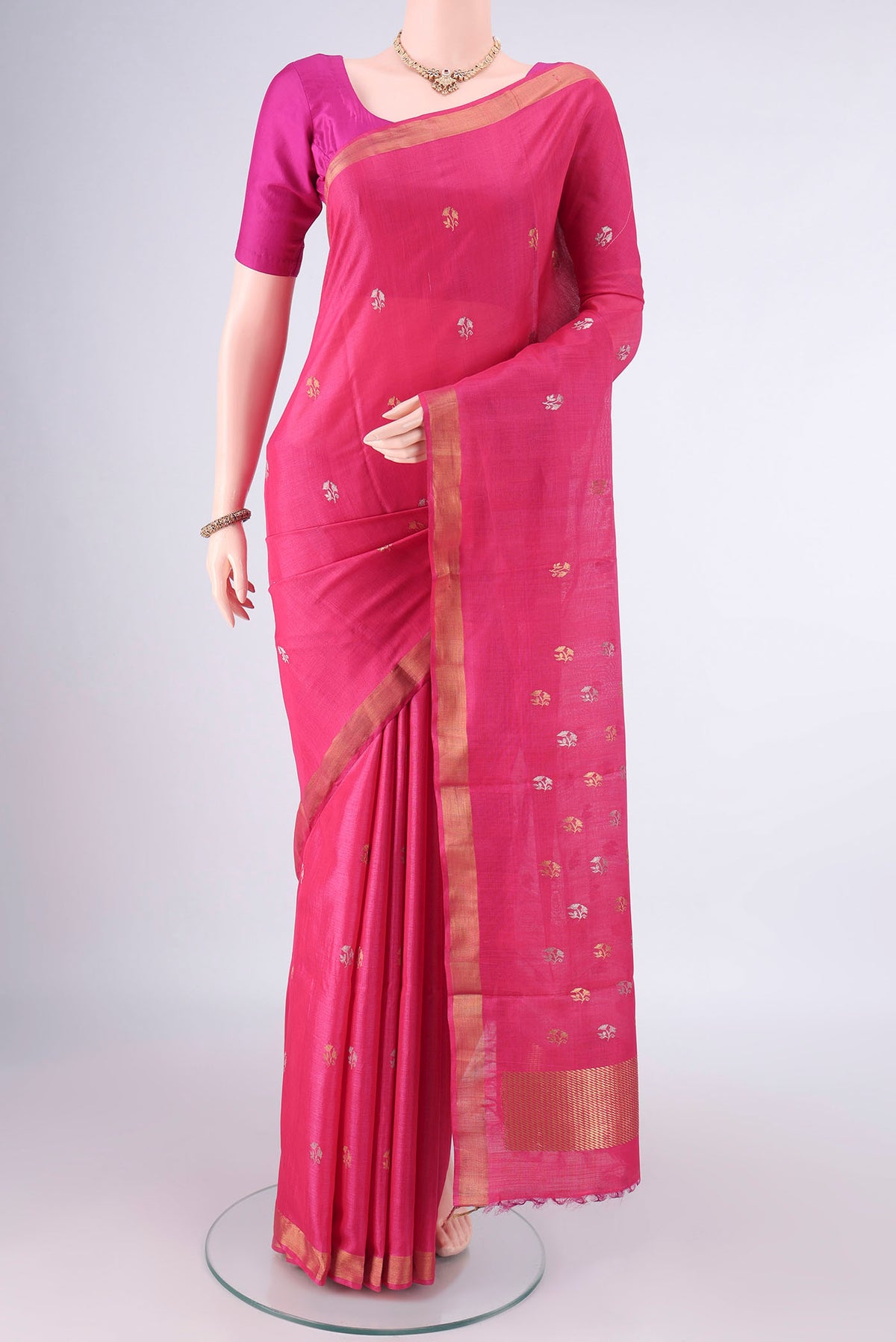 Rani Pink MP Tussar Saree with Zari Butta on the body and Zari Border.  displayed on a mannequin