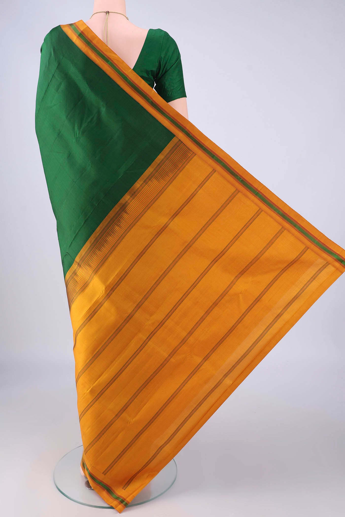 Flat view of Bottle Green Kanjivaram Silk Saree with Plain Body and Thread Border. 