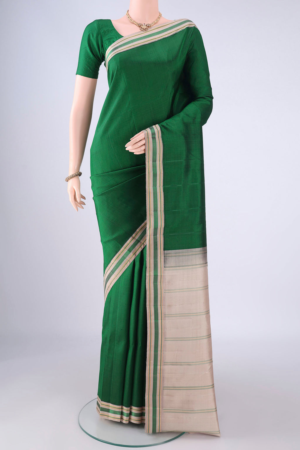 Green Kanjivaram Silk Saree with Plain Body and Thread Border.  displayed on a mannequin
