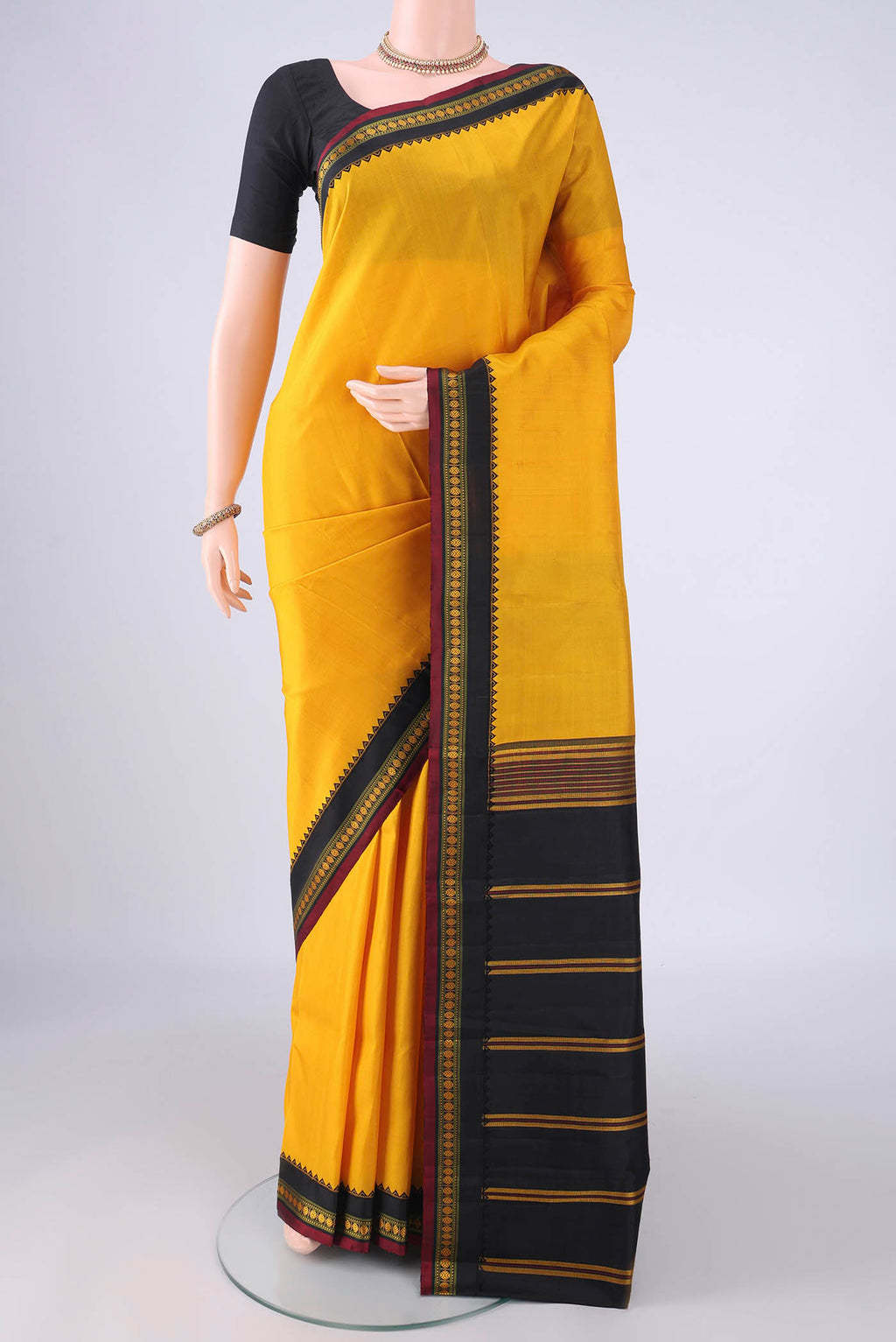 Yellow Kanjivaram Silk Saree with Plain Body and Thread Border.  displayed on a mannequin