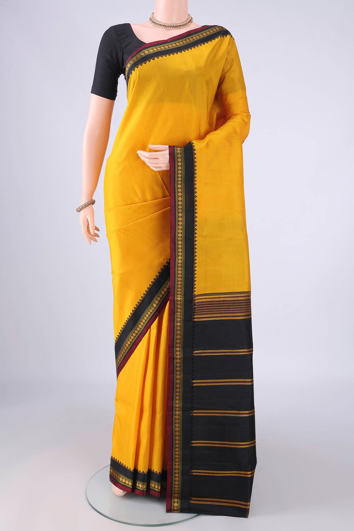 Yellow Kanjivaram Silk Saree with Plain Body and Thread Border.  displayed on a mannequin