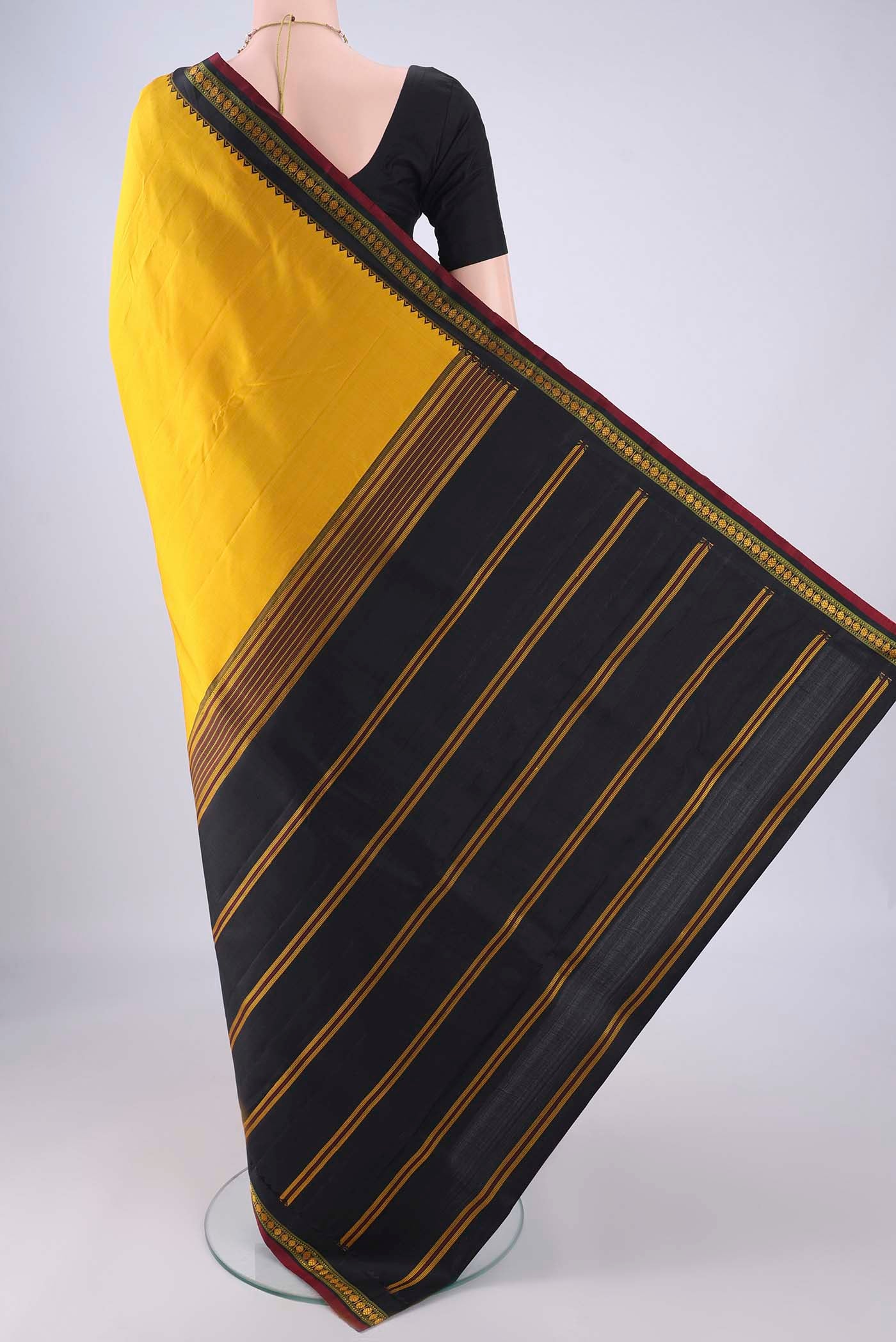 Flat view of Yellow Kanjivaram Silk Saree with Plain Body and Thread Border. 
