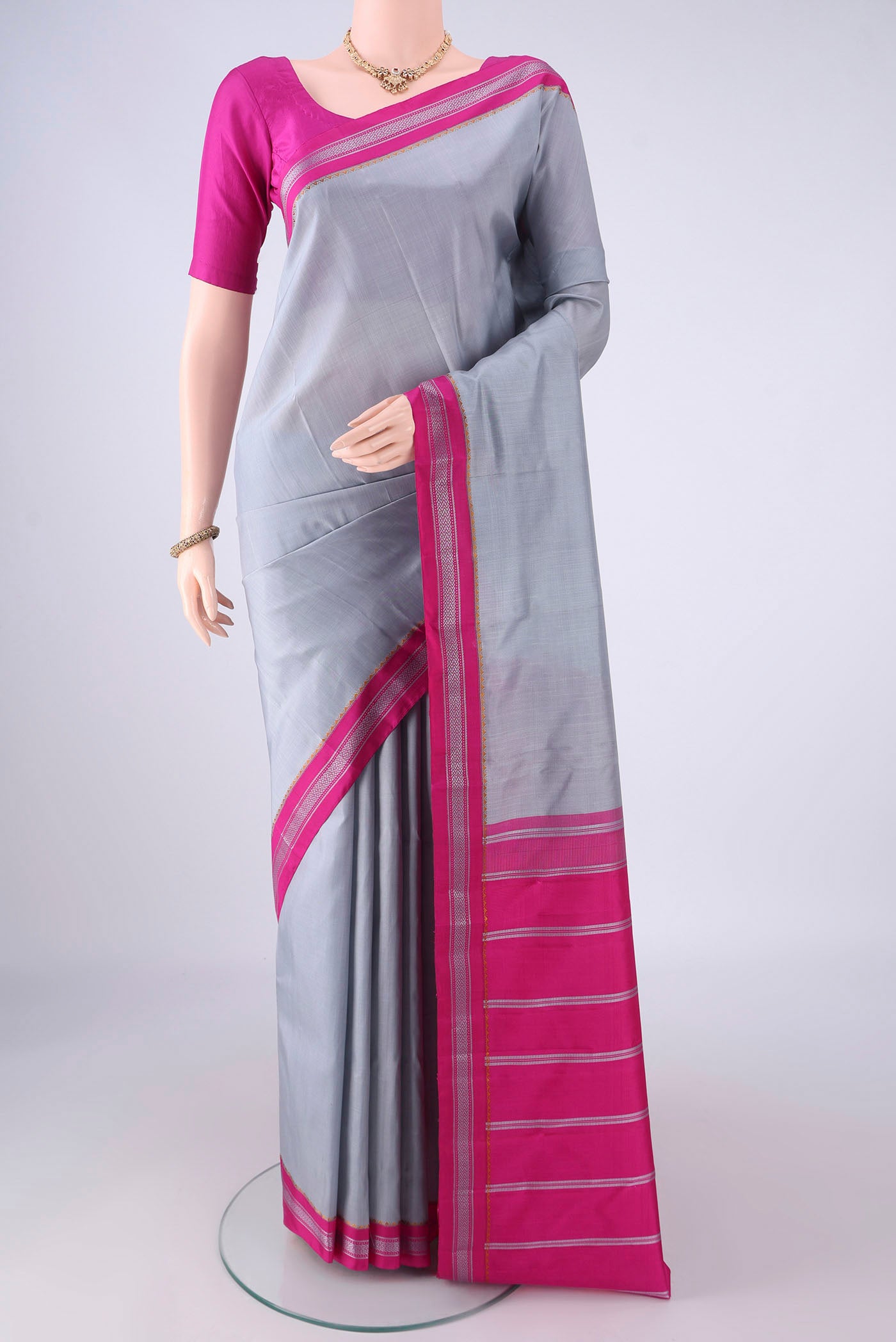 Grey Kanjivaram Silk Saree with Plain Body and Thread Border.  displayed on a mannequin