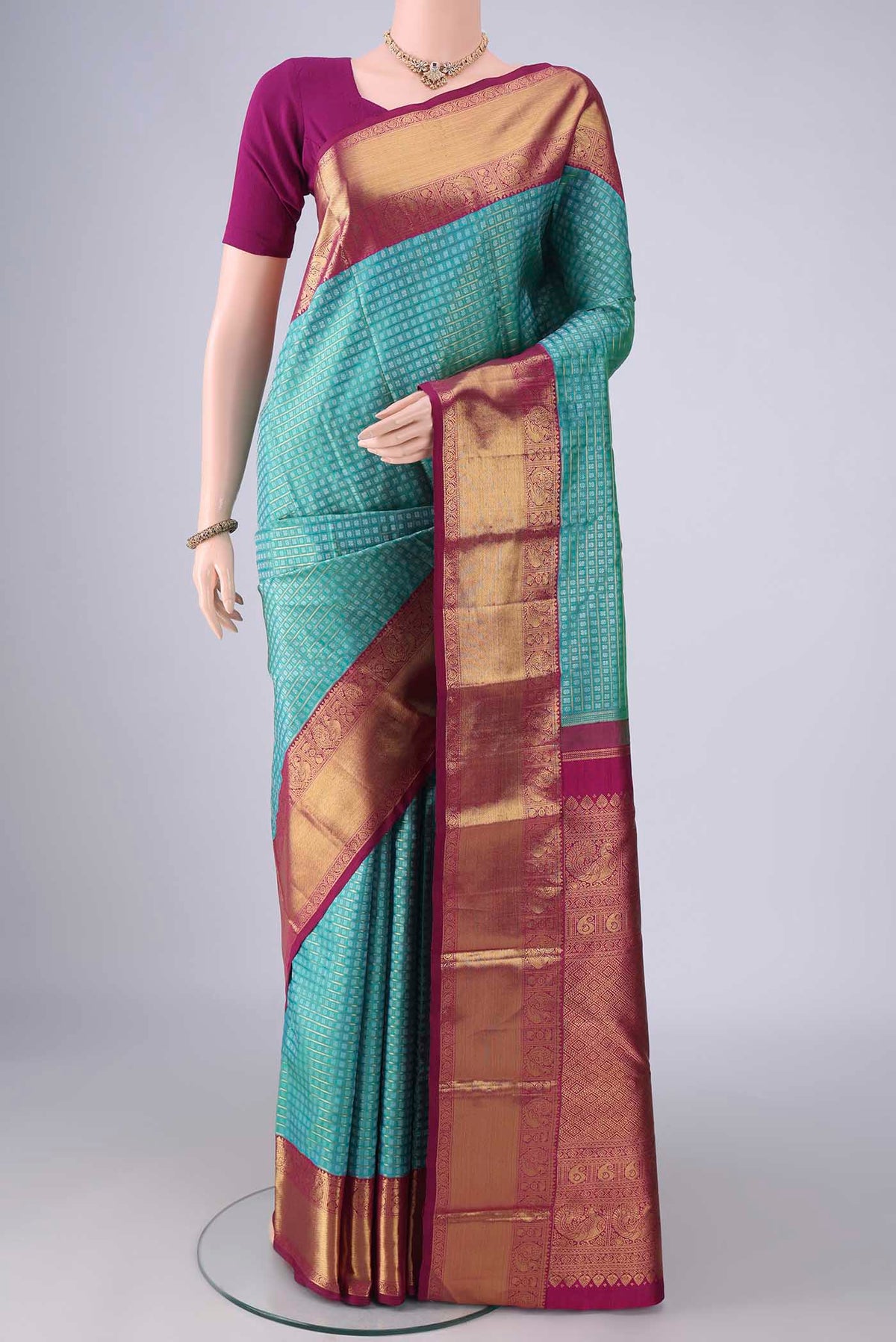 Pure Silk Pure Zari Turquoise Kanjivaram Saree with Jacquard design on the body and Zari Border.  displayed on a mannequin