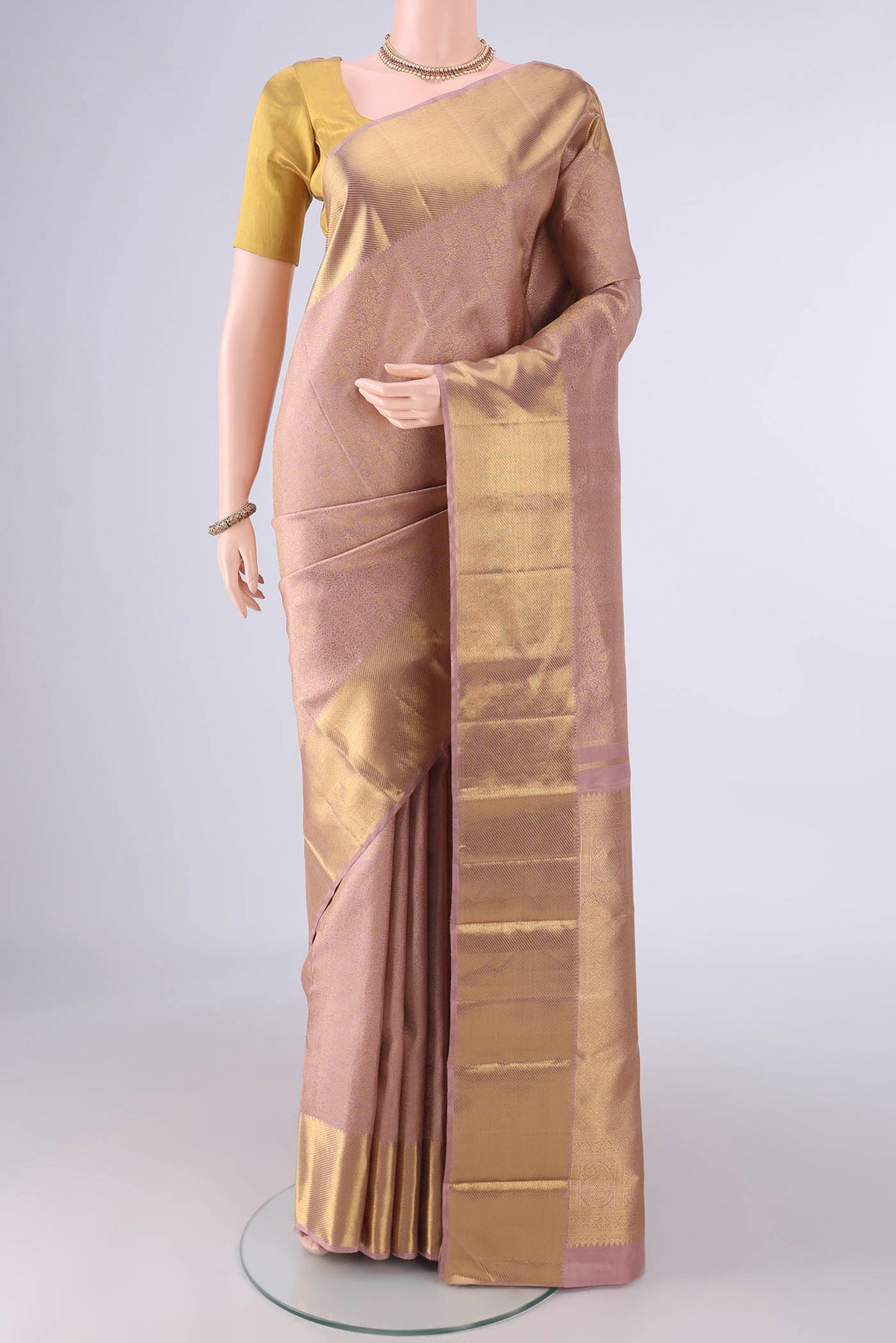 Pure Silk Pure Zari Rose Gold Kanjivaram Saree with Zari Brocade on the body and Zari Border.  displayed on a mannequin