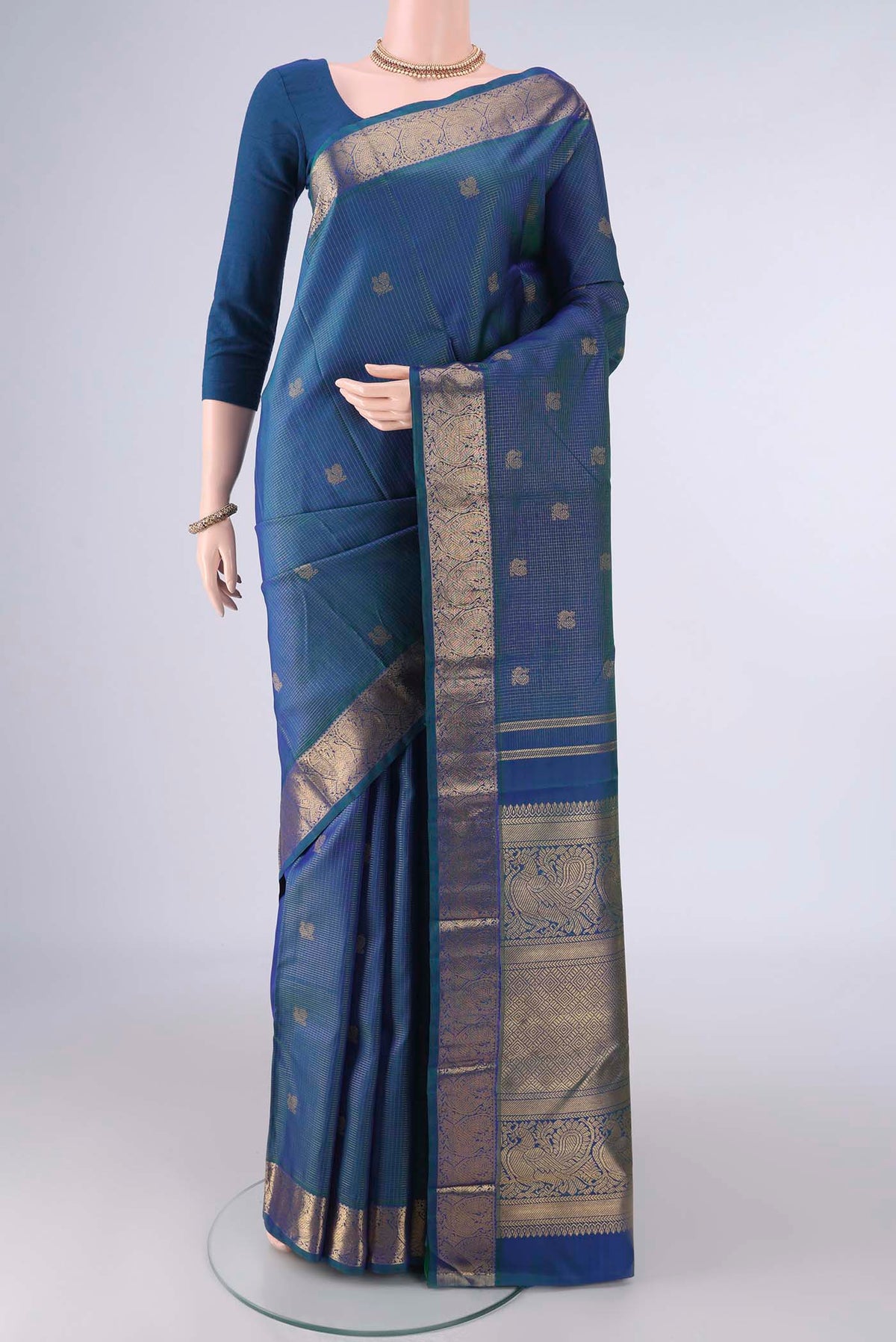 Pure Silk Pure Zari Peacock Blue Dual Tone Kanjivaram Saree with Checked design on the body and Zari Border.  displayed on a mannequin