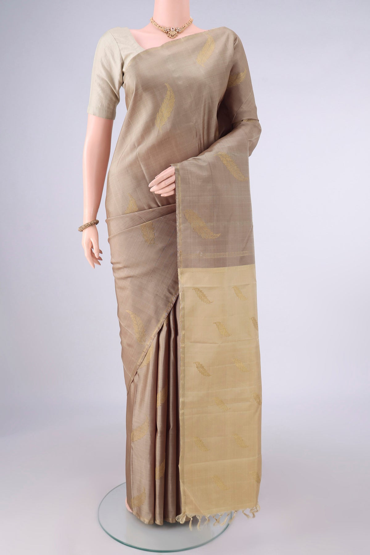 Pure Silk Pure Zari Dark Beige Kanchipuram Saree with Zari Butta on the body and Zari Border.  displayed on a mannequin
