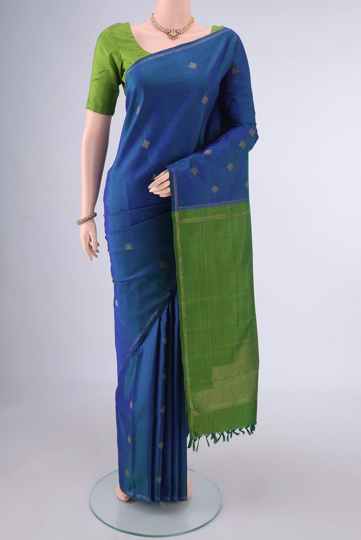 Pure Silk Pure Zari Peacock Blue Kanchipuram Saree with Zari Butta on the body and Thin Zari Line.  displayed on a mannequin
