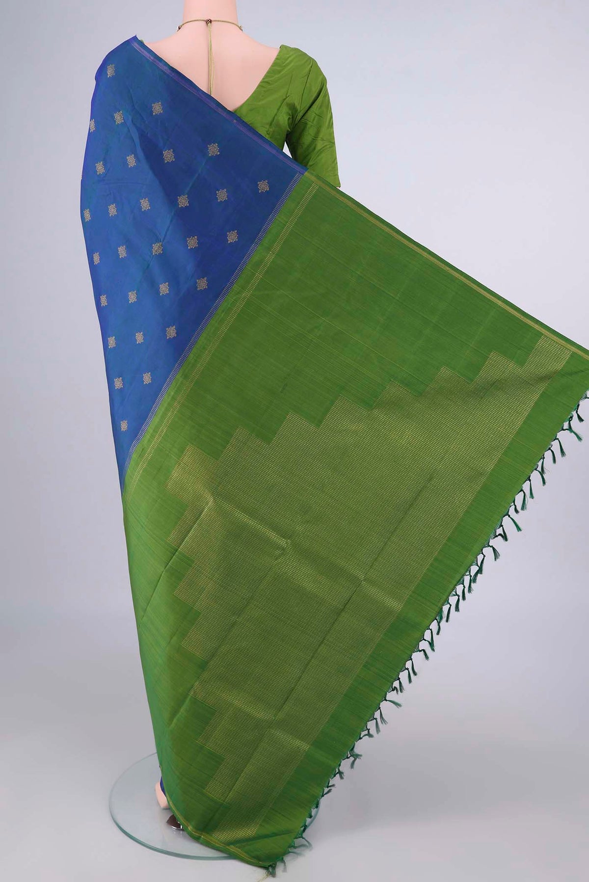 Flat view of Pure Silk Pure Zari Peacock Blue Kanchipuram Saree with Zari Butta on the body and Thin Zari Line. 