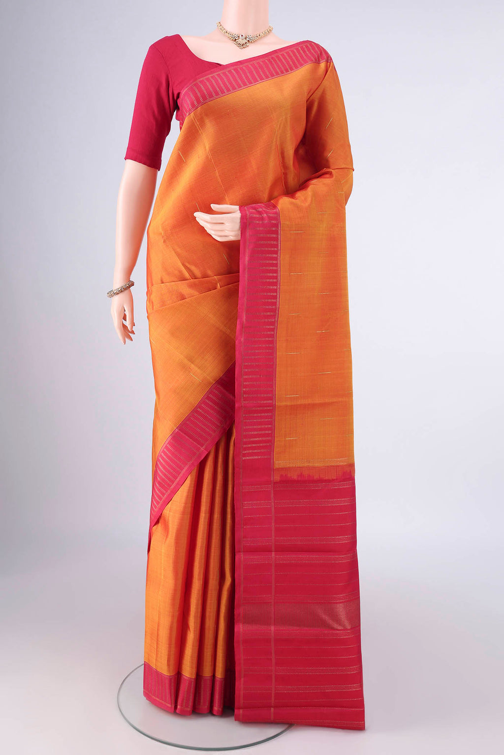 Pure Silk Orange Kanchipuram Saree with Plain Body and Zari Border.  displayed on a mannequin