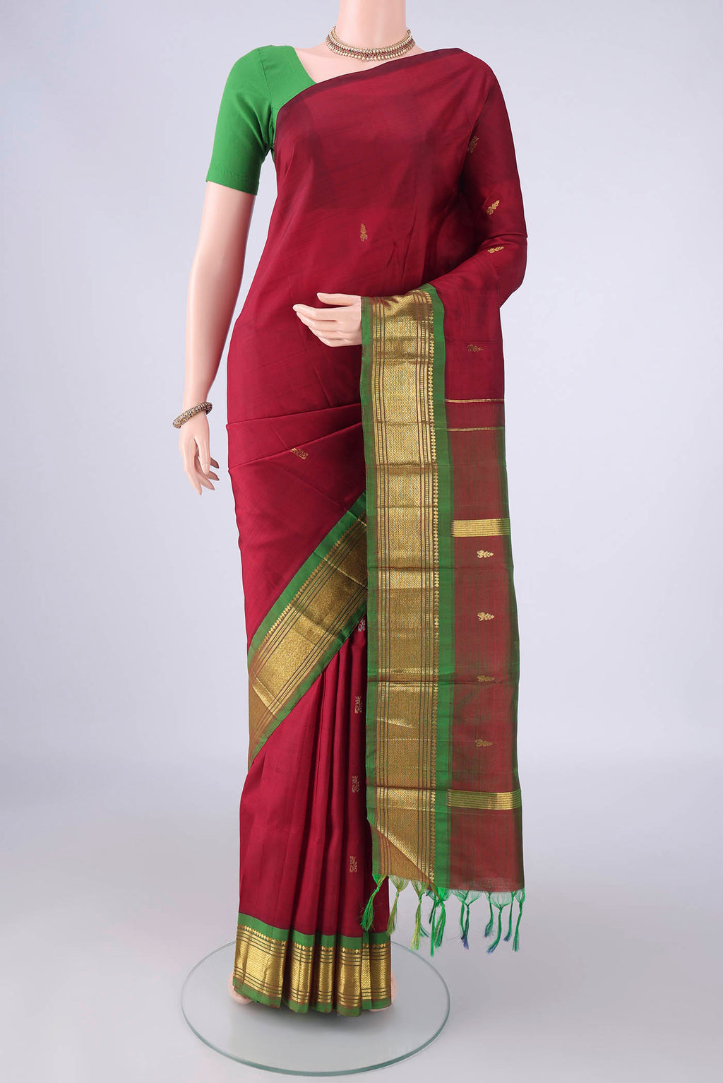 Maroon Kanjivaram Silk Saree with Zari Butta on the body and One Side Border.  displayed on a mannequin
