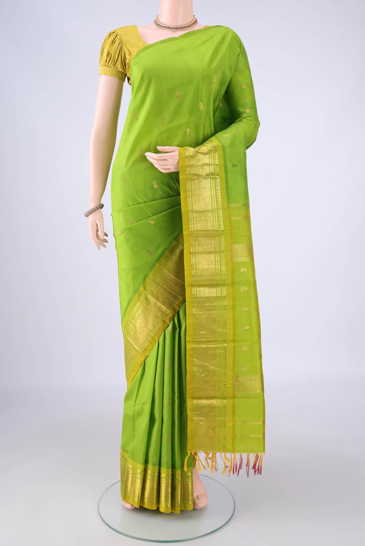 Light Green Kanjivaram Silk Saree with Zari Butta on the body and One Side Border.  displayed on a mannequin