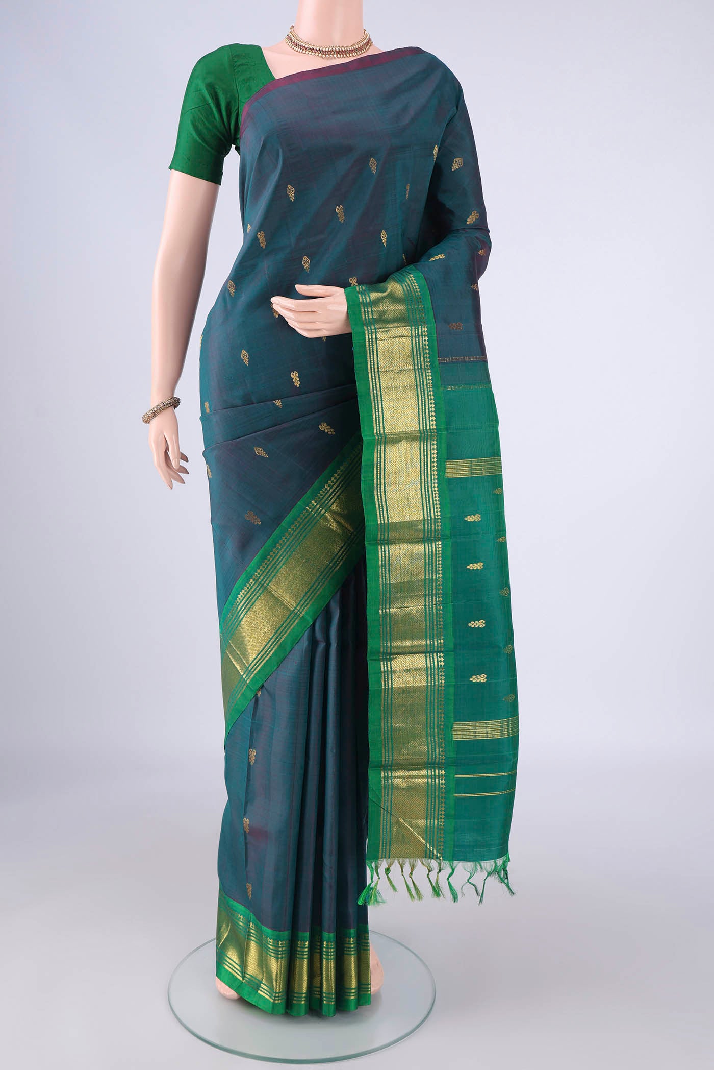Peacock Blue Dual Tone Kanjivaram Silk Saree with Zari Butta on the body and One Side Border.  displayed on a mannequin