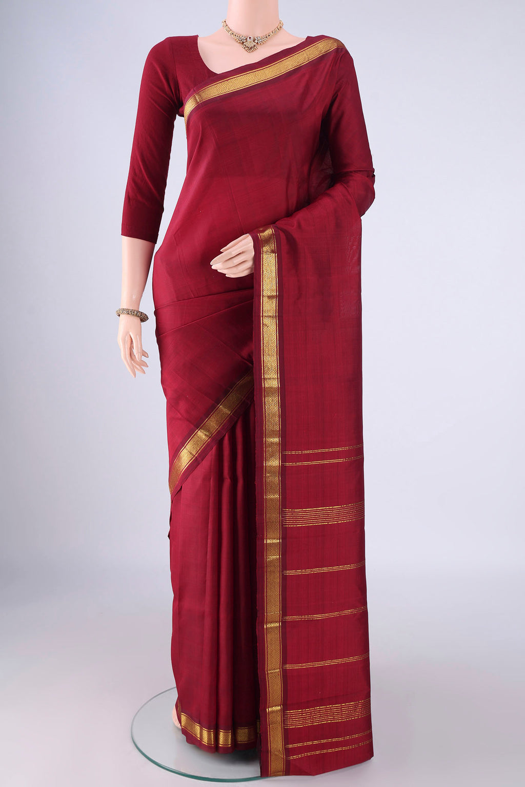 Maroon Kanjivaram Silk Saree with Plain Body and Zari Border.  displayed on a mannequin