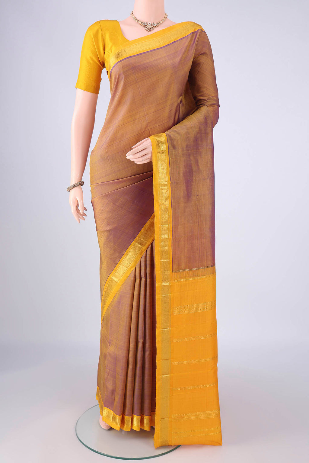 Pure Silk Bronze Dual Tone Kanjivaram Silk Saree with Plain Body and Zari Border.  displayed on a mannequin