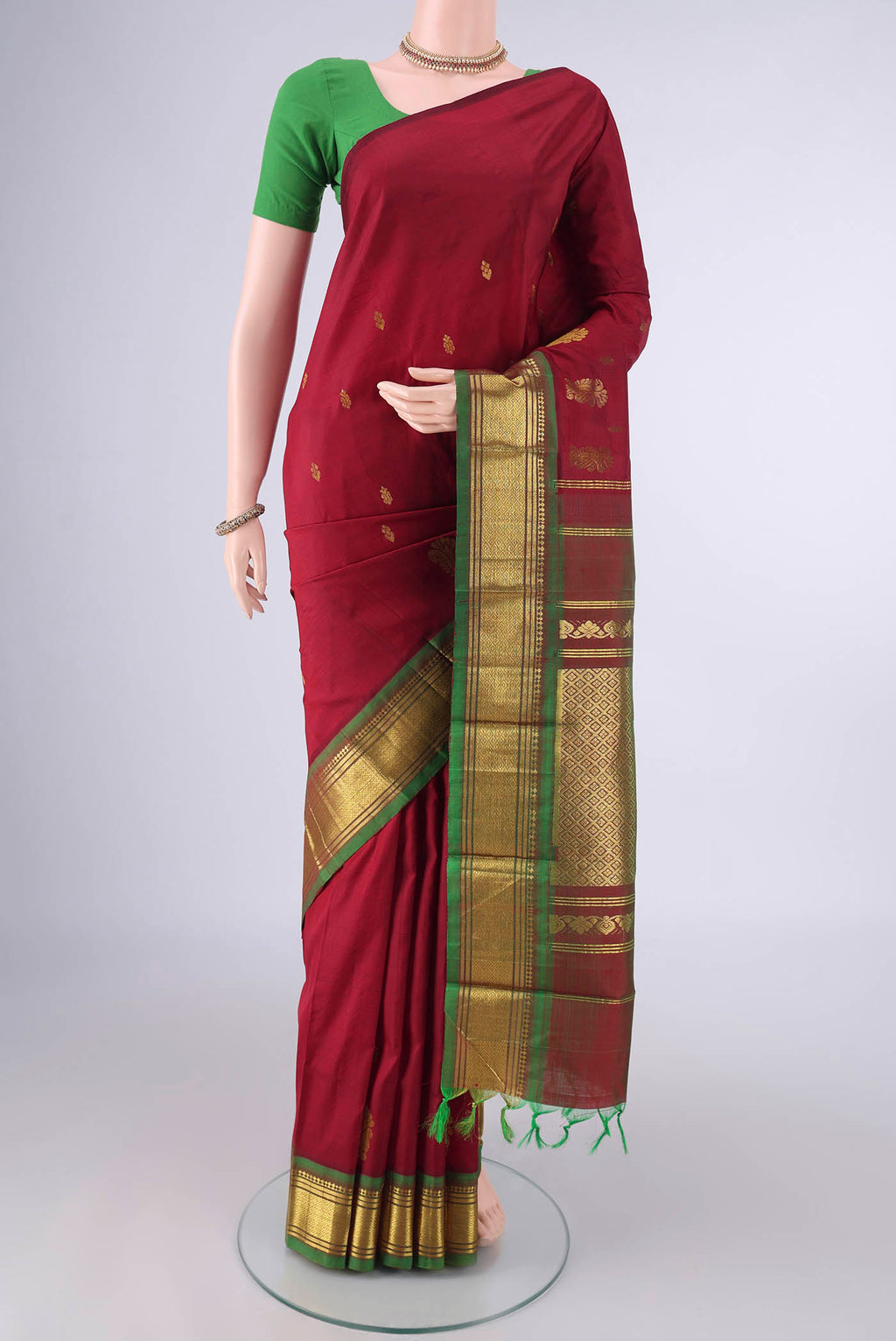 Pure Silk Maroon Kanjivaram Saree with Zari Butta on the body and One Side Border.  displayed on a mannequin