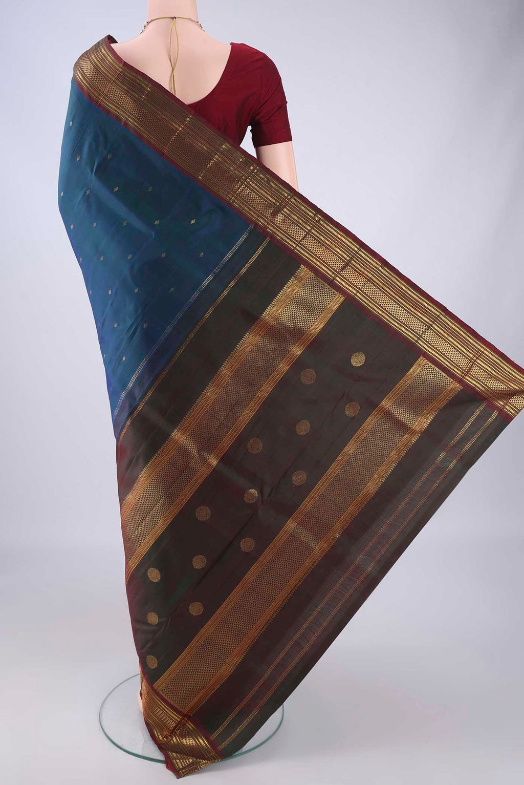 Flat view of Pure Silk Peacock Blue Kanchipuram Silk Saree with Zari Butta on the body and Zari Border. 