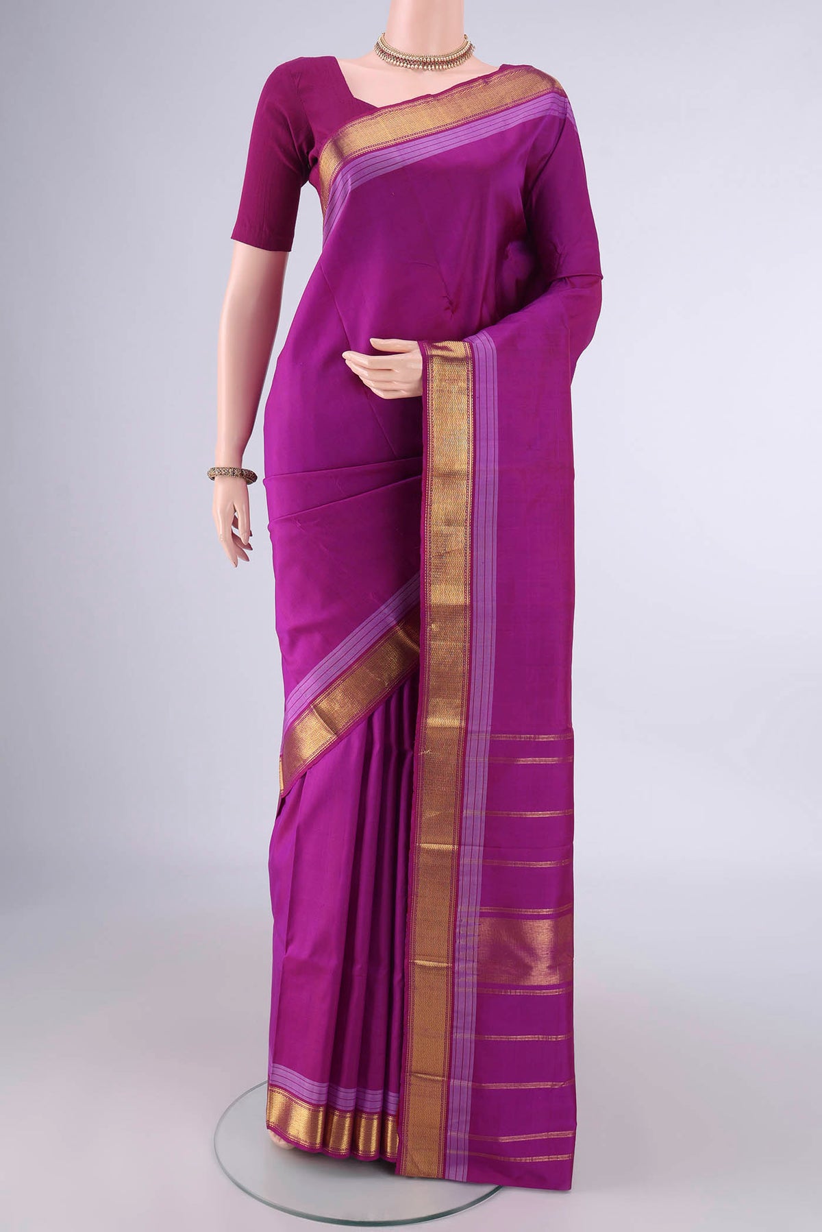 Pure Silk Magenta Kanjivaram Saree with Plain Body and Zari Border.  displayed on a mannequin