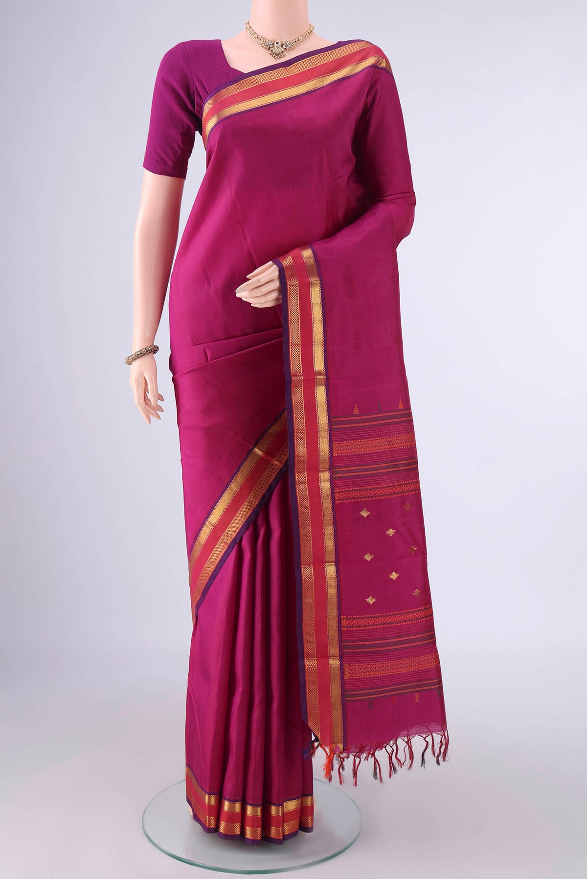 Pure Silk Dark Pink Kanjivaram Saree with Plain Body and Zari Border.  displayed on a mannequin